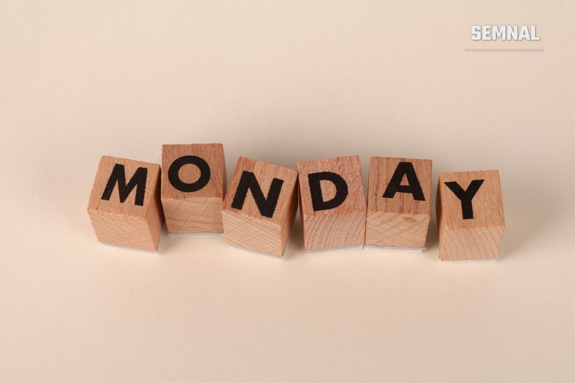 Șase cuburi din lemn cu literele negre care formează cuvântul 'MONDAY', ilustrând tema zilelor săptămânii și originea denumirilor acestora în limba engleză și alte limbi europene.