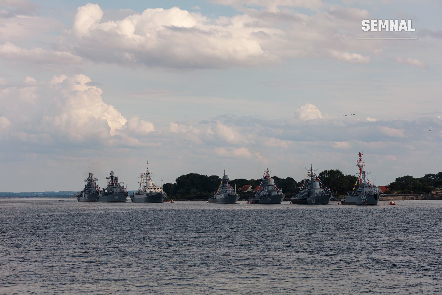 Flota de nave militare moderne cu fregate și corvete ancorate în apă, echipate cu sisteme de armament și radare, în context de securitate maritimă regională din Asia.
