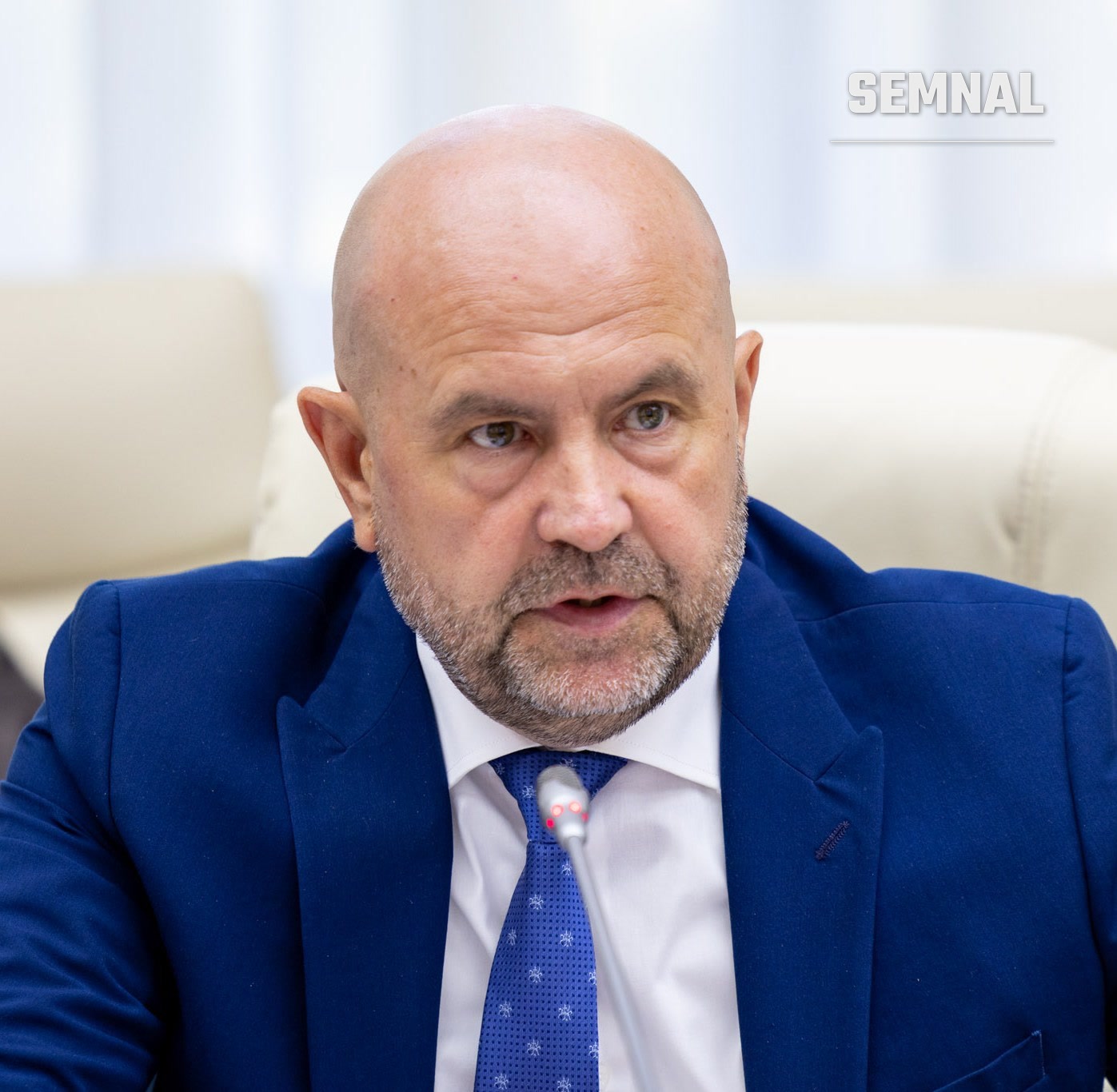 Vladimir Bolea, vicepremier, în portret de presă purtând costum albastru și cravată, fotografiat la o ședință oficială cu fundal de canapele (Foto: Government of Moldova)