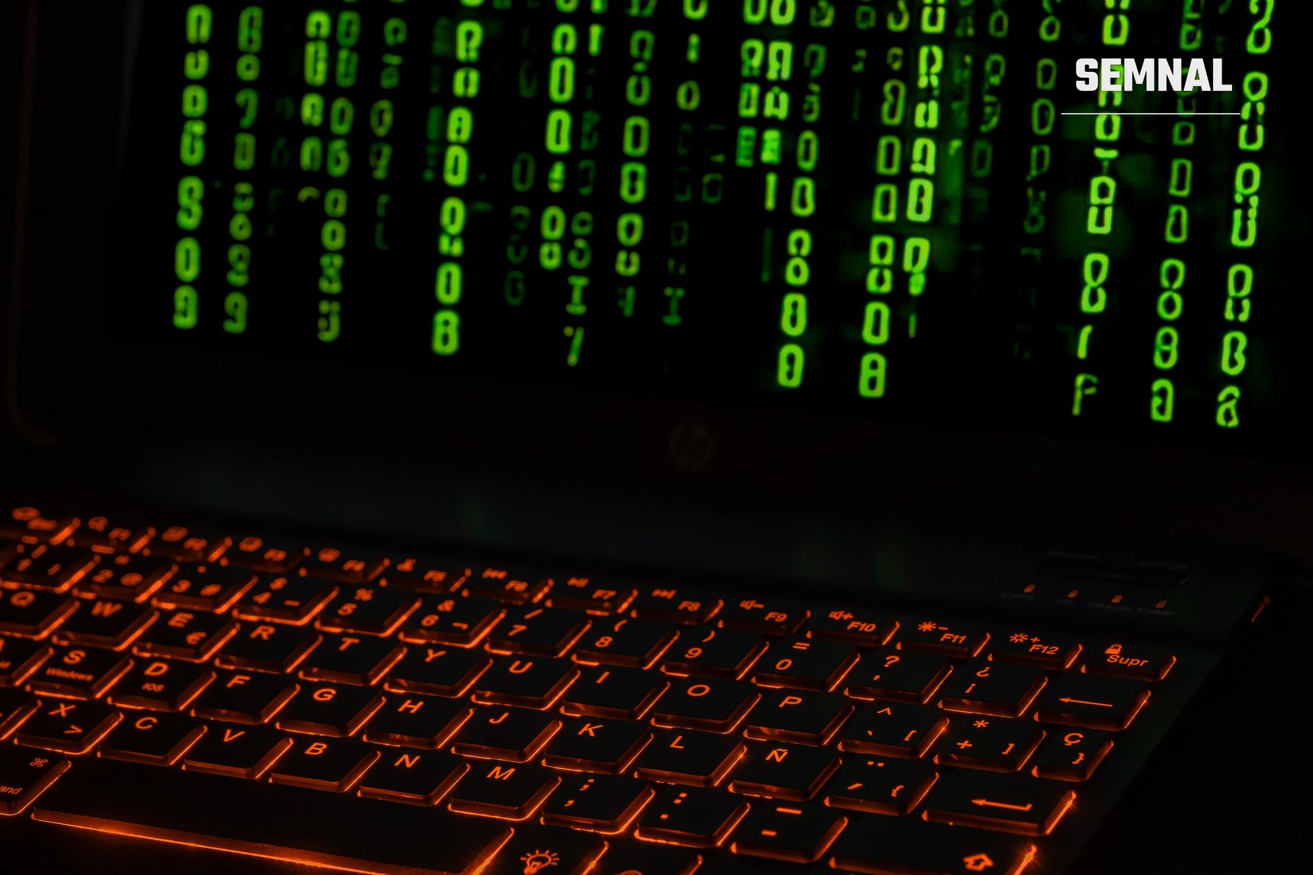 Tastatură cu iluminare roșie și cod binar verde pe ecran negru, simbolizând un atac cibernetic și breșa de securitate informatică. (Foto: Rafael Minguet Delgado / Pexels)