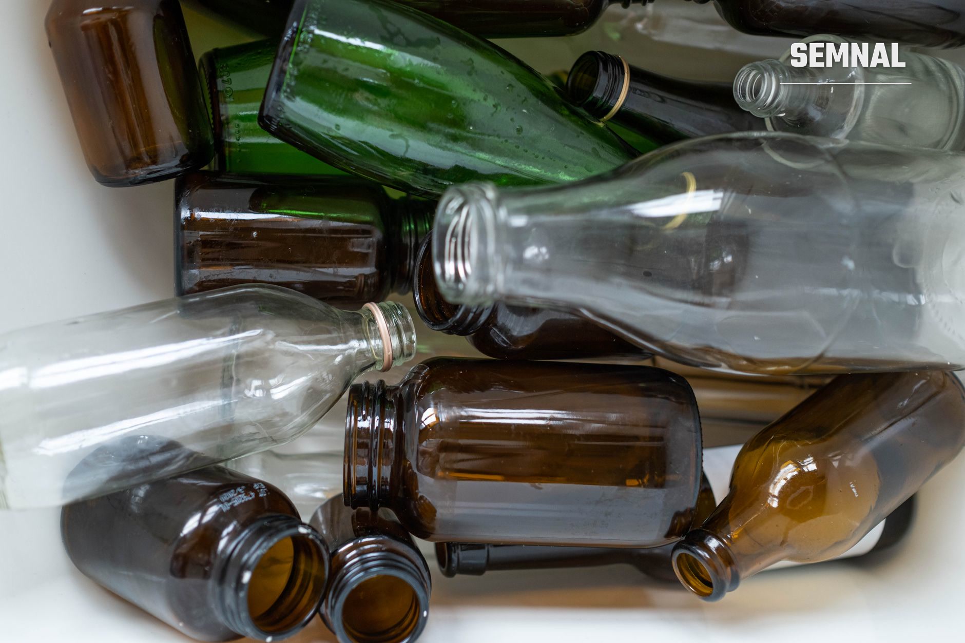 Colecție de sticle și borcane goale în diverse culori și dimensiuni, reciclabile, dispuse pentru colectare și reutilizare conform sistemului de garanție pe ambalaje. (Foto: Ron Lach / Pexels)