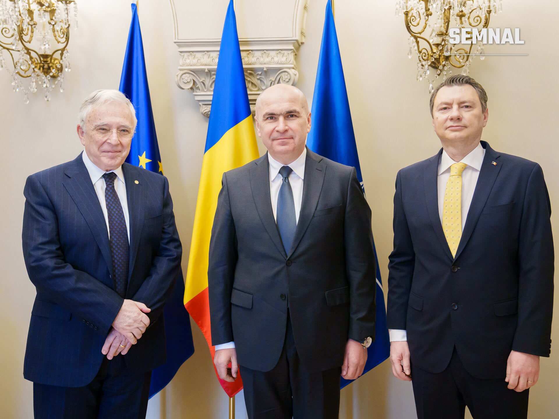 Mugur Isărescu, Guvernatorul Băncii Naționale a României, în oficiu la o întâlnire protocolară oficială alături de doi colegi, în fața drapelelor. (Foto: Presidential Administration of Romania)