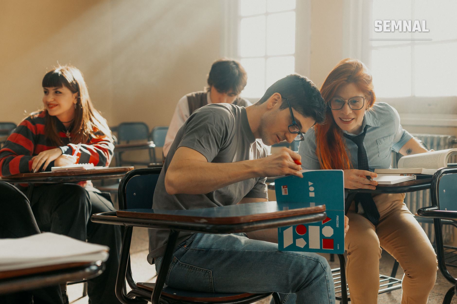 Grup de patru tineri în sala de clasă care lucrează colaborativ la un proiect cu material didactic colorat, ilustrând reintegrarea educațională și activitatea de grup în contexte școlare reformate. (Foto: Gera Cejas / Pexels)