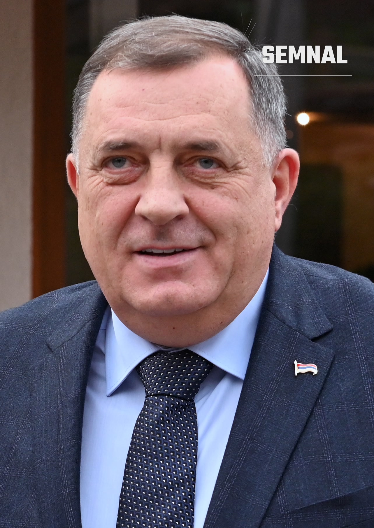 Milorad Dodik, barbat in varsta cu par grizonat, zâmbind la camera, purtând costum gri și cravată neagră cu insigna steagului pe piept (Foto: European Commission)