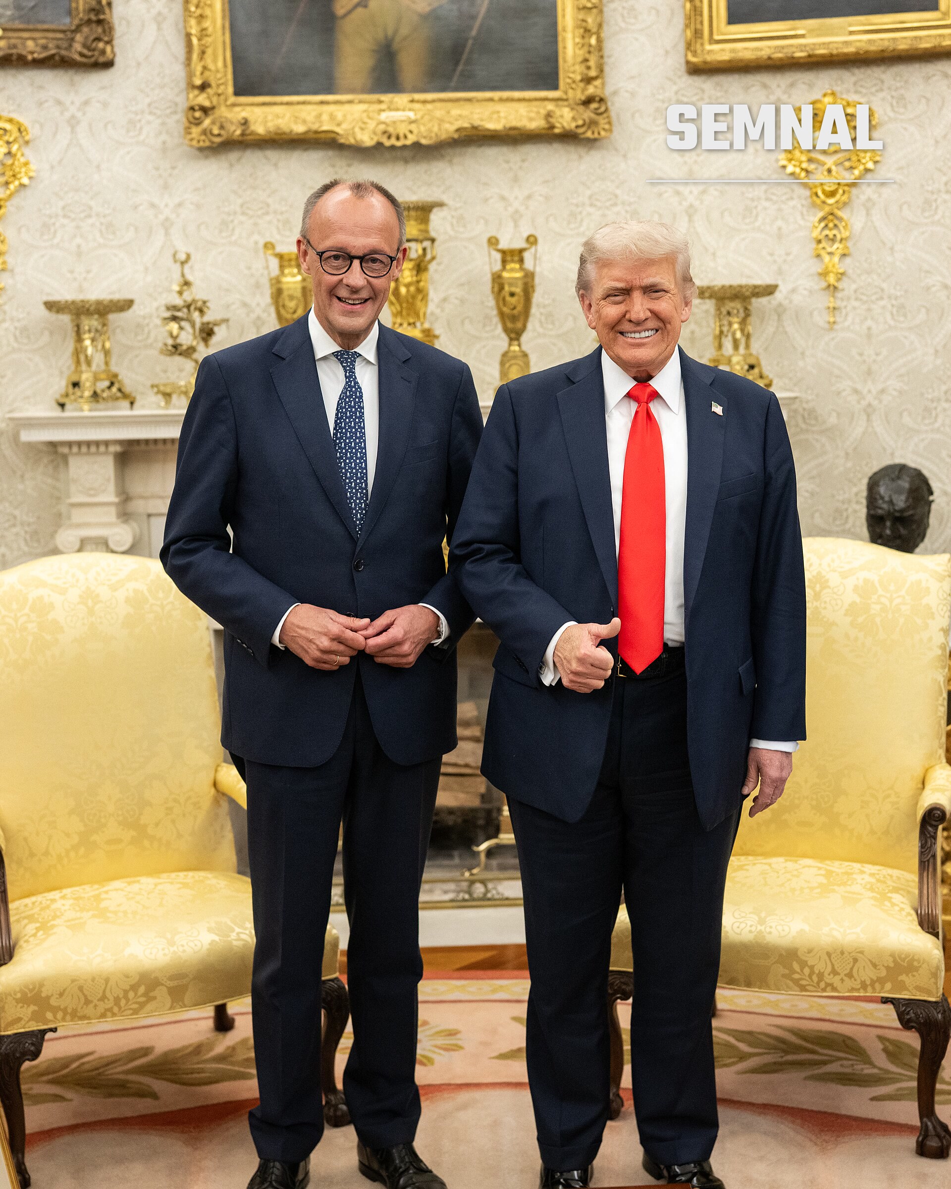 Friedrich Merz, cancelar al Germaniei, în costum negru cu cravată albastră și ochelari, zâmbind în salonul oficial Oval, alături de o altă persoană în costum negru cu cravată roșie. (Foto: The White House)