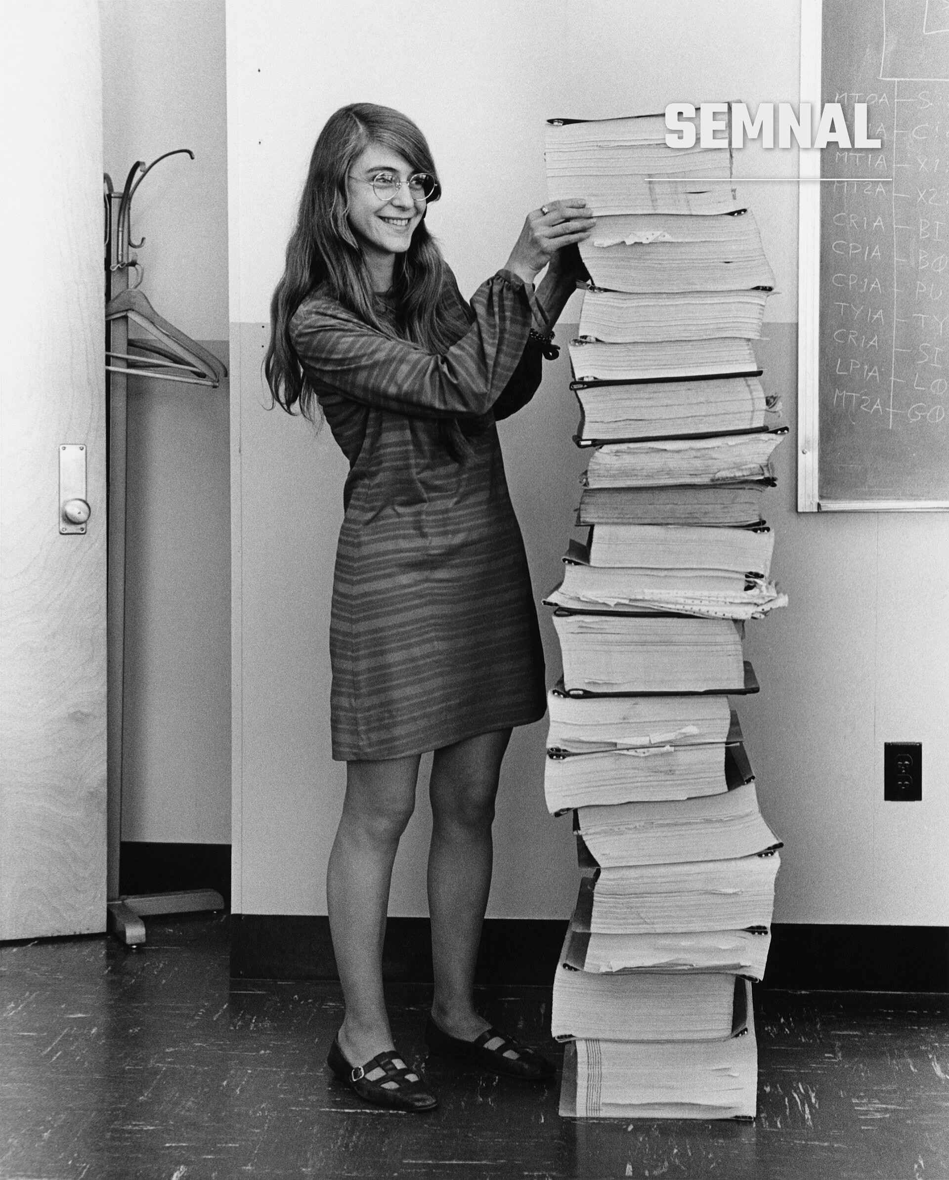 Margaret Hamilton, în 1969, lângă un teanc de listări cu codul sursă al software-ului de navigație Apollo scris de echipa ei la MIT (Foto: MIT Draper Laboratory, restaurare Adam Cuerden / Wikimedia Commons)