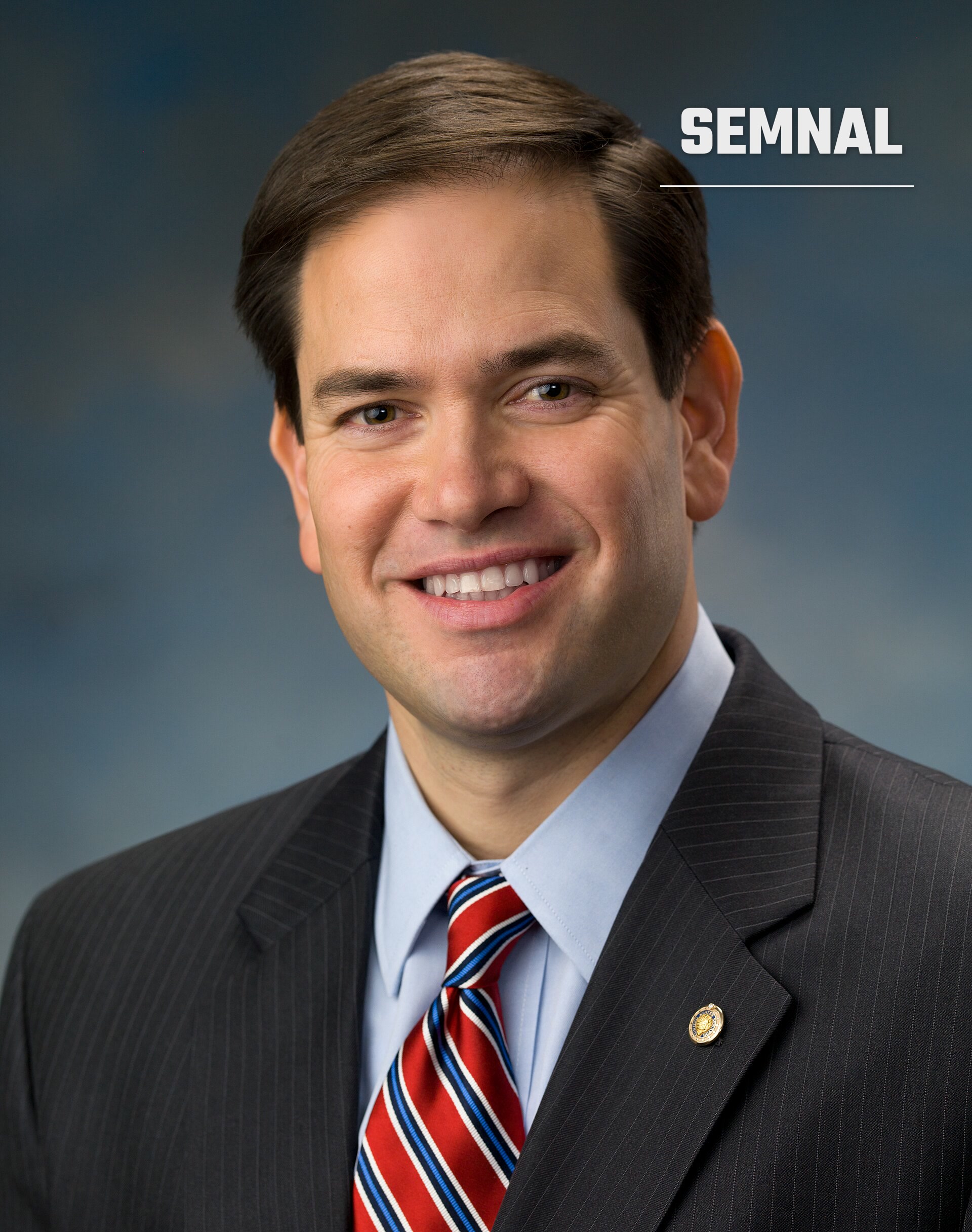 Marco Rubio, secretar de stat, portret de presa in costum negru si cravata rosie, cu fata vizibila si zambet, pe fundal gri-albastru. (Foto: US Senate)