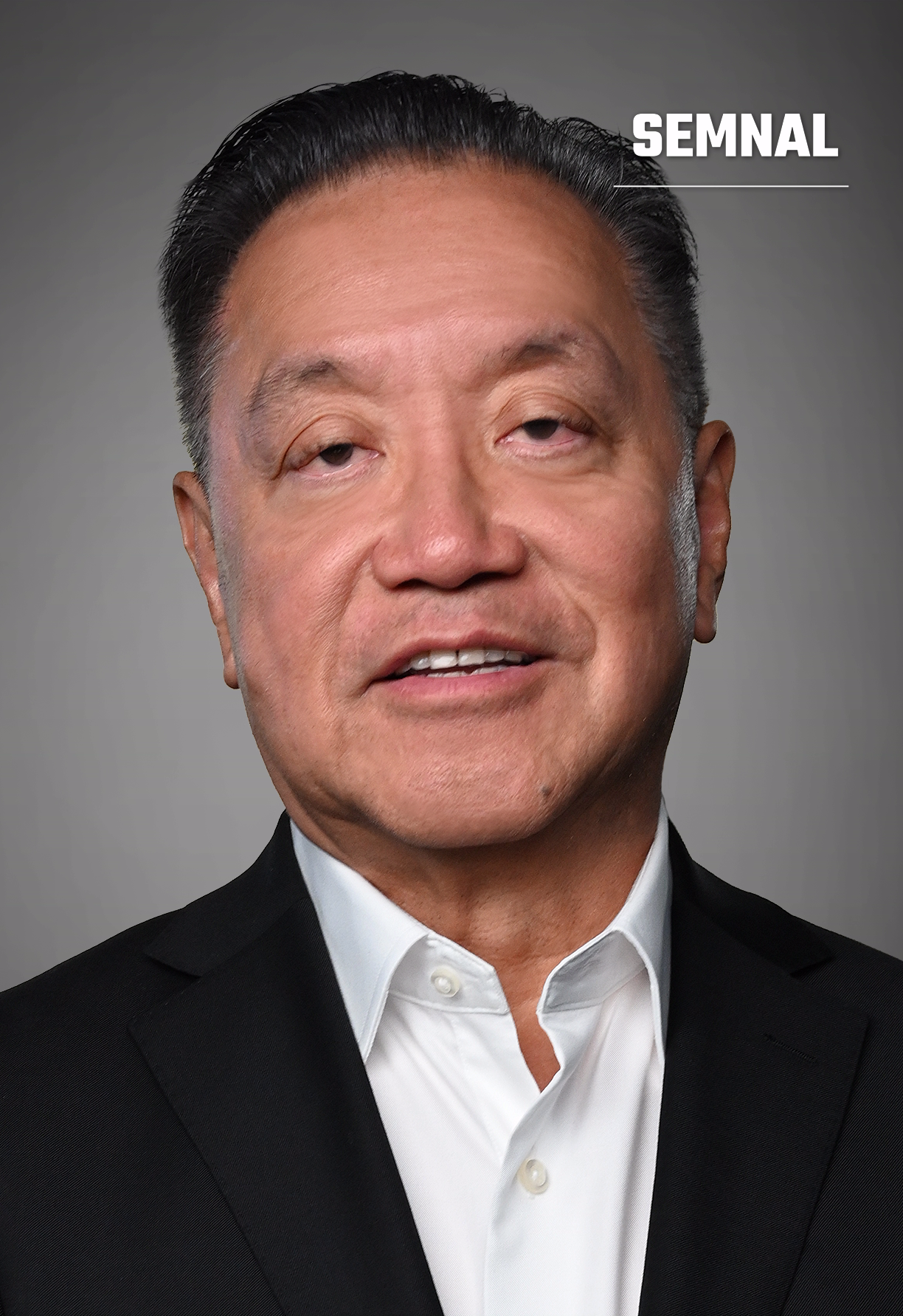 Hock Tan, bărbat în costum negru și cămașă albă, pe fundal gri de studio, privind spre cameră. (Foto: Greg Bezat, d/b/a Bezat Video Group)