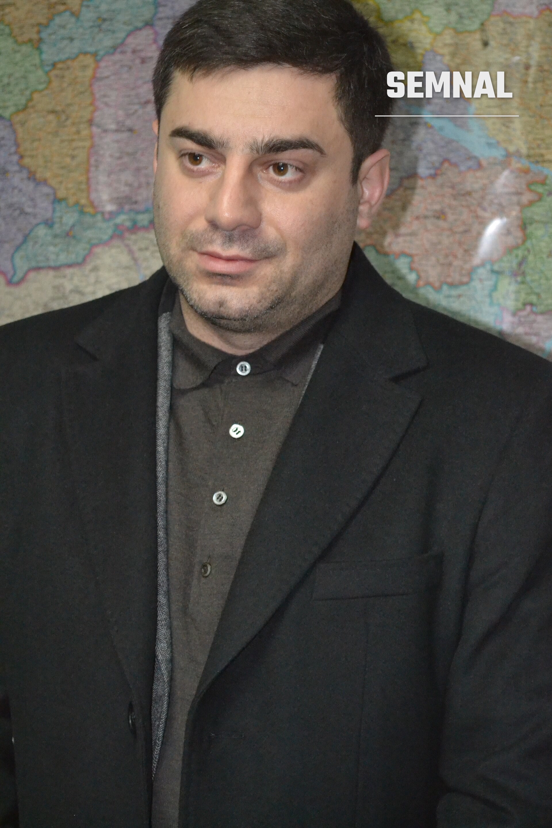 Dmytro Lubinets, comisarul pentru drepturile omului al Radei Supreme, într-un sacou negru, în fața unei hărți politice colorate. (Foto: Ivasykus)