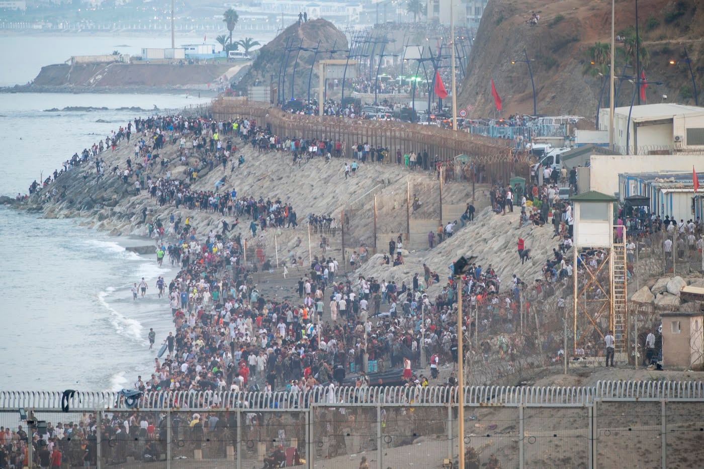 Mii de persoane pe digul de la Tarajal, la frontiera dintre Maroc și enclava spaniolă Ceuta, lângă gardul de frontieră și un turn de observație