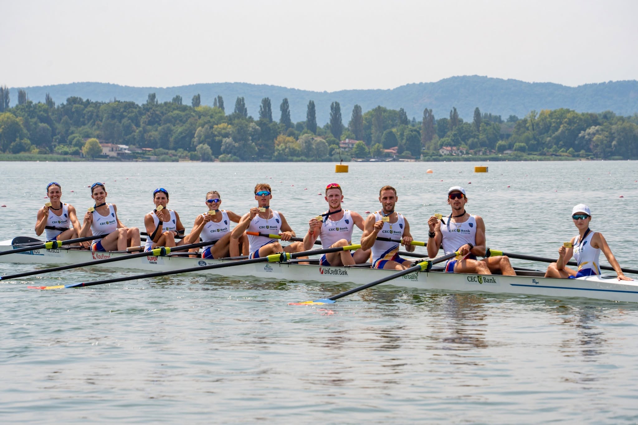 Sportivi din echipa României de canotaj sărbătoresc pe apă după câștigarea unei medalii la Campionatele Europene de la Varese