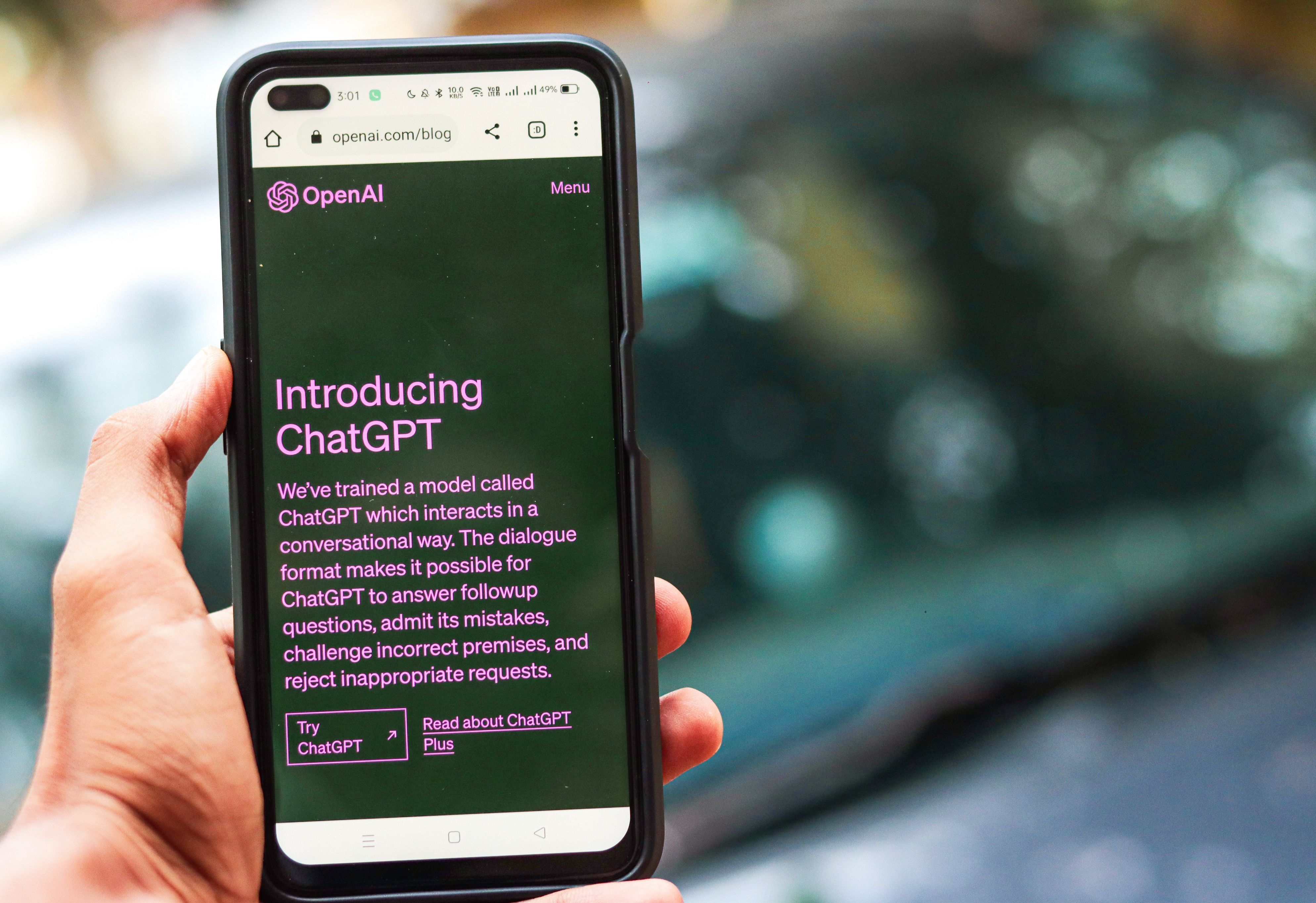 O persoană ține în mână un telefon mobil pe care este afișată aplicația ChatGPT