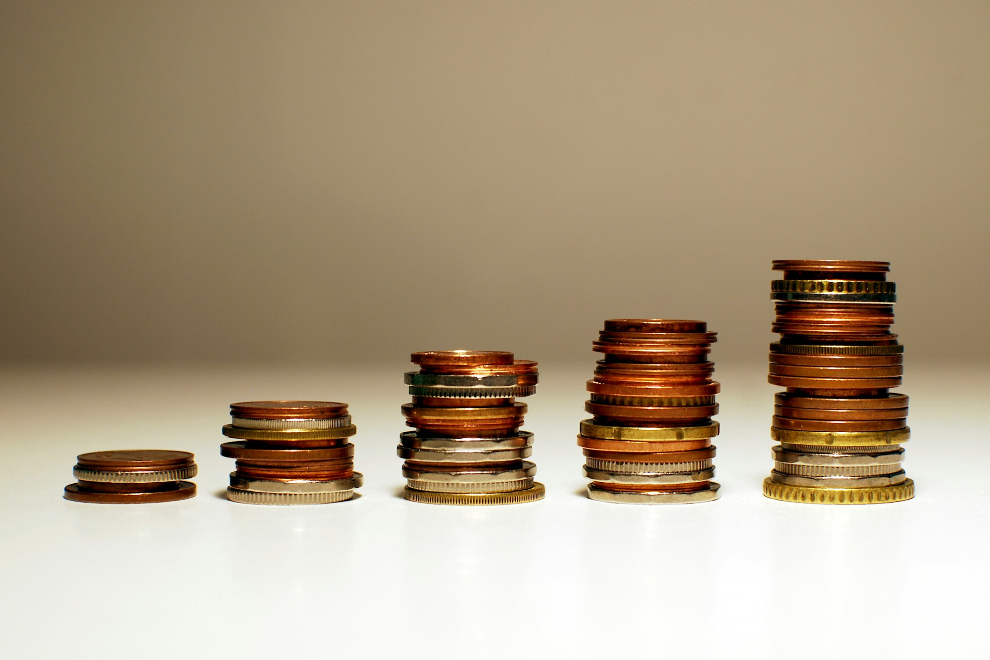 Coloane de monede de dimensiuni crescătoare, simbolizând acumularea economiilor pentru pensie