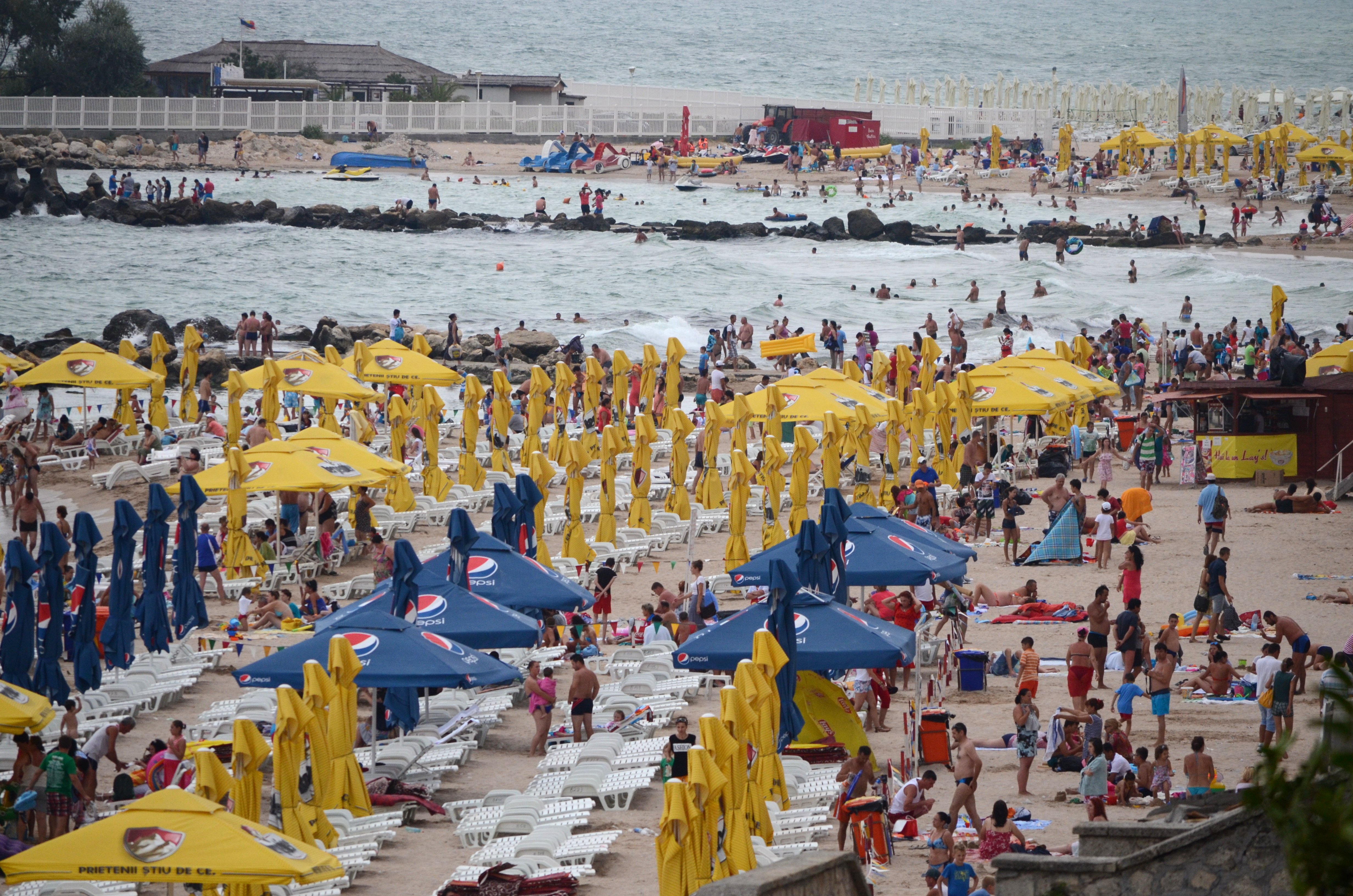 Plaja din Eforie Nord, plină de turiști, cu umbrele și șezlonguri, vedere spre Marea Neagră