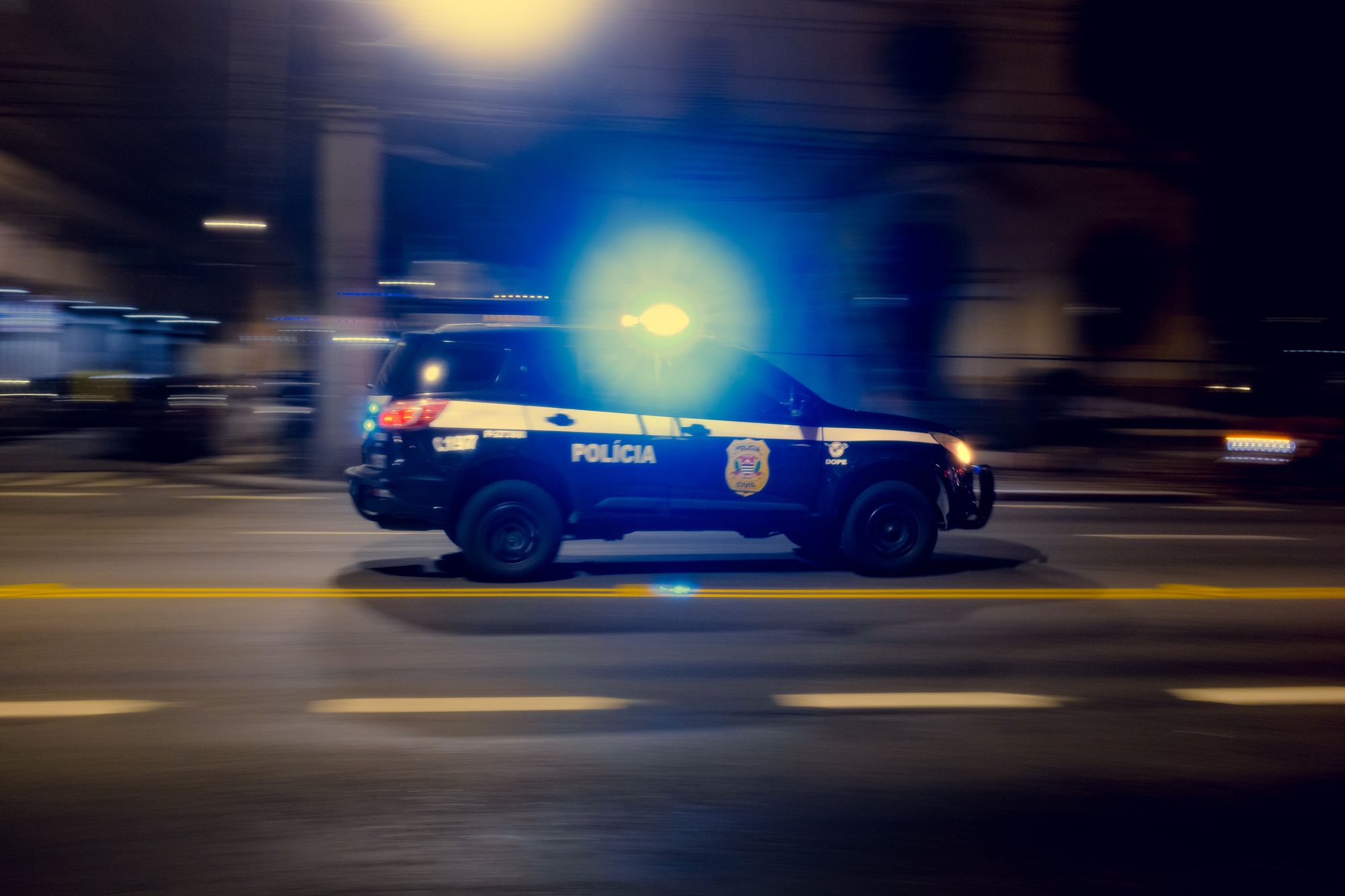 Mașină de poliție cu girofarul aprins, noaptea