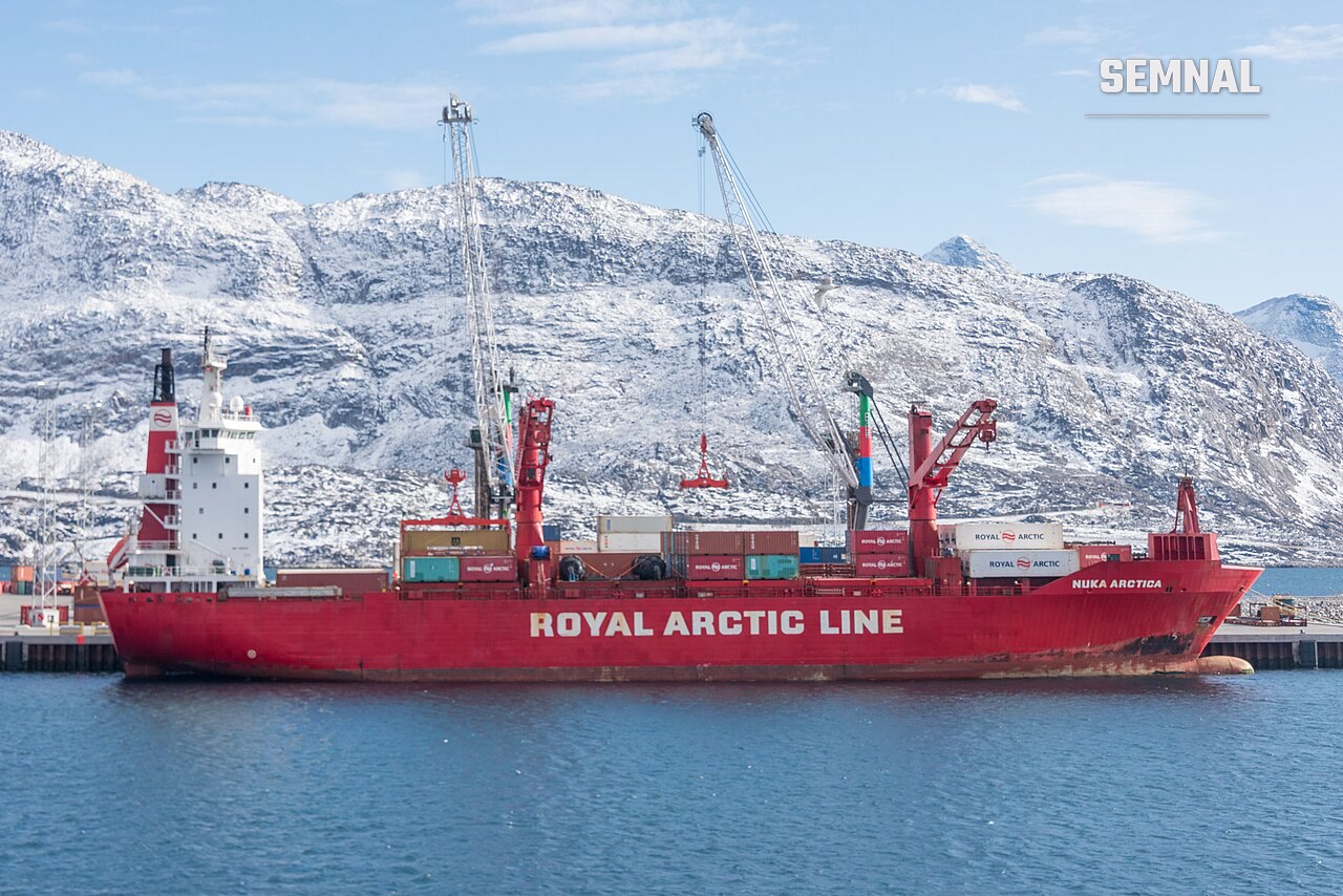 Navă de containere navigând în ape arctice, lângă un port din Groenlanda