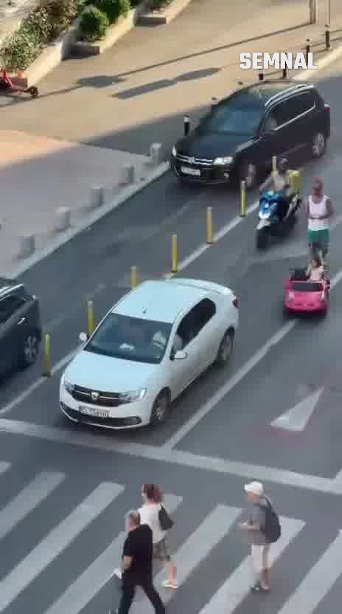 Mașinuță electrică roz de jucărie, cu un copil la volan, în trafic pe o stradă din București, alături de un scuter și un bărbat care merge pe lângă