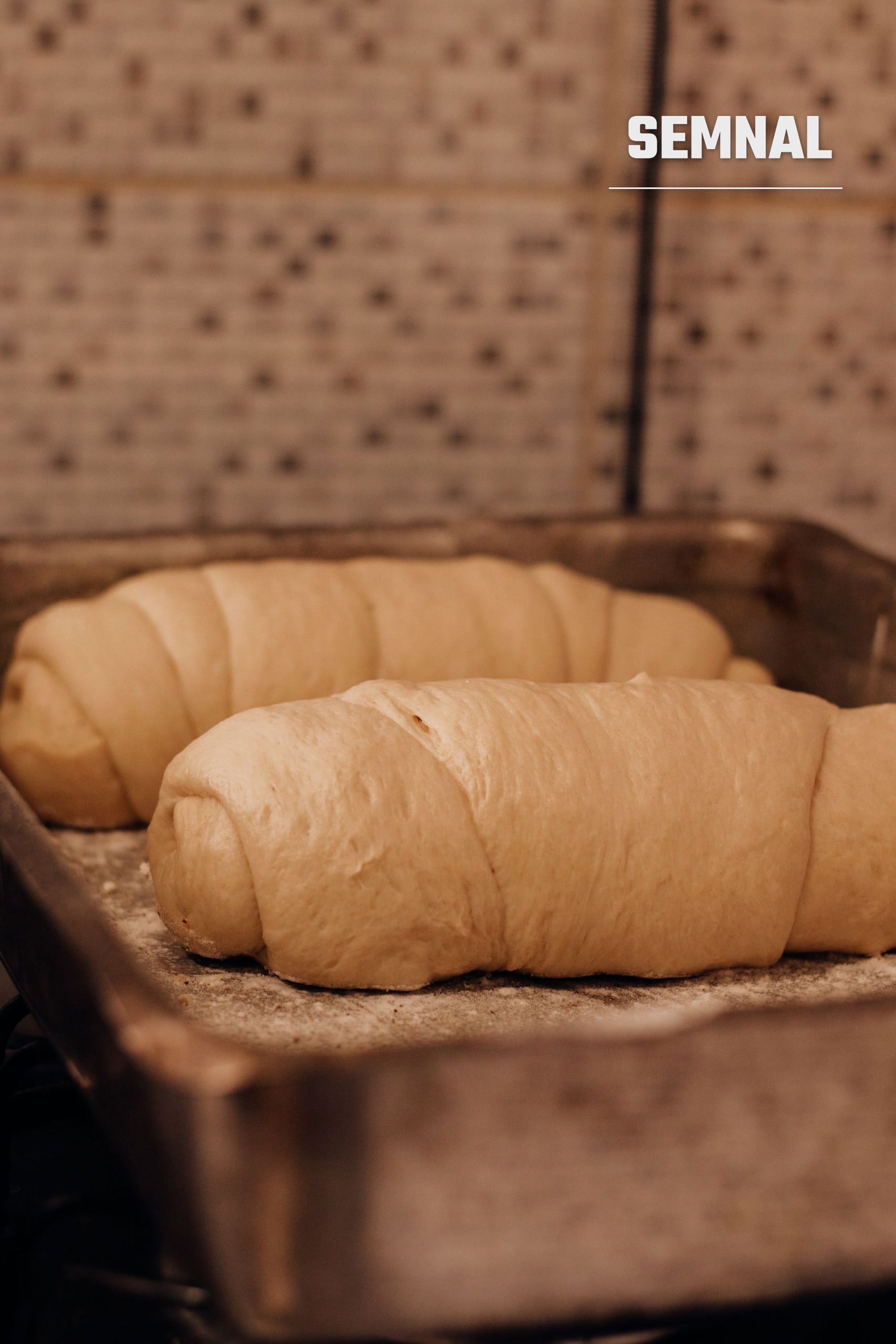 Croissante crude pe o tavă, pregătite pentru copt, imagine ilustrativă