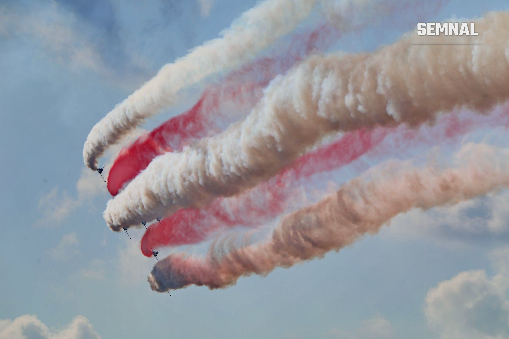 Trenele de fum roșu și alb lăsate de aeronavele NF-5 ale formației Turkish Stars, la o ediție anterioară a mitingului de la Băneasa