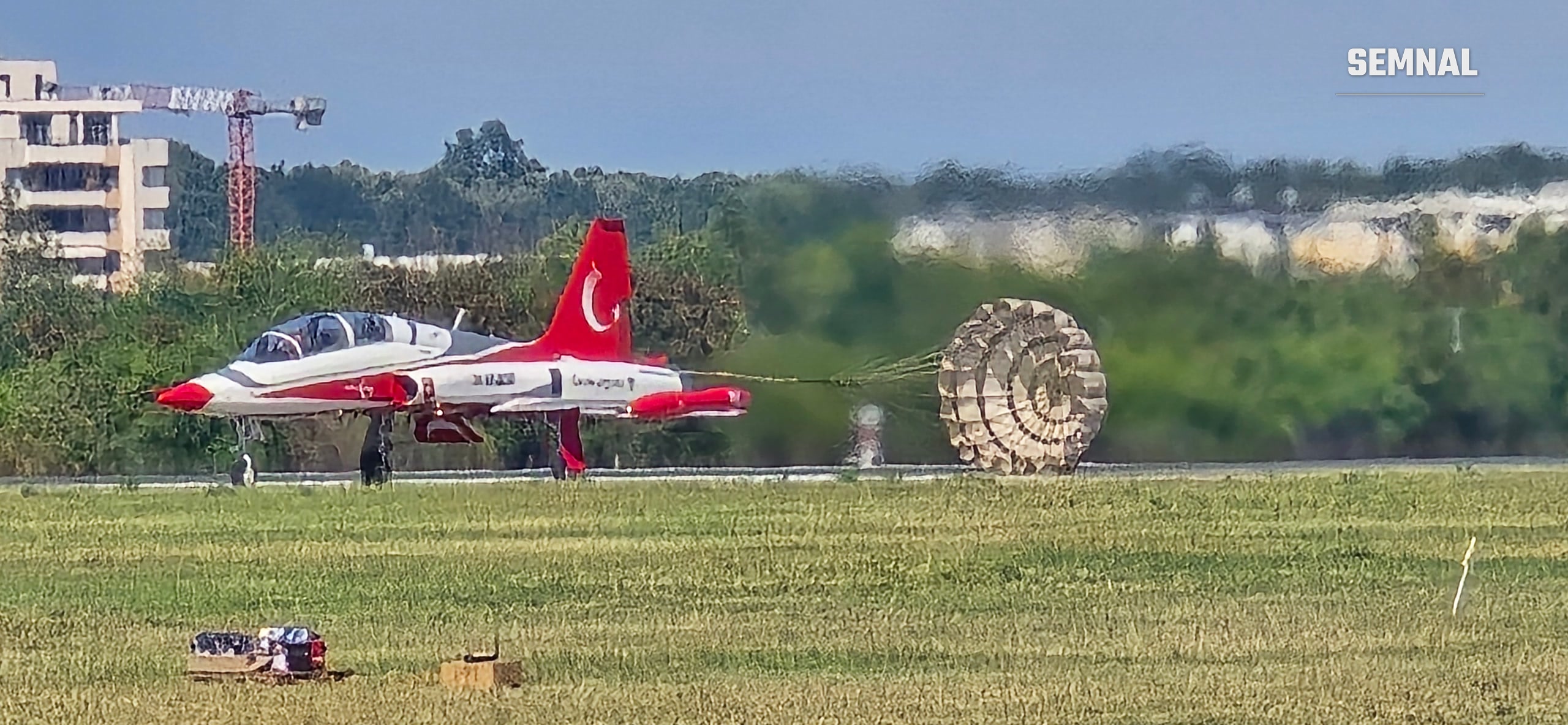 Un NF-5 frânează pe pistă cu parașuta de frânare desfăcută, după aterizare