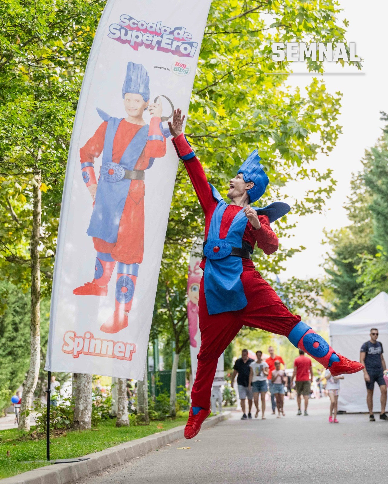 Spinner, personajul care activează energia, lângă unul dintre steagurile evenimentului