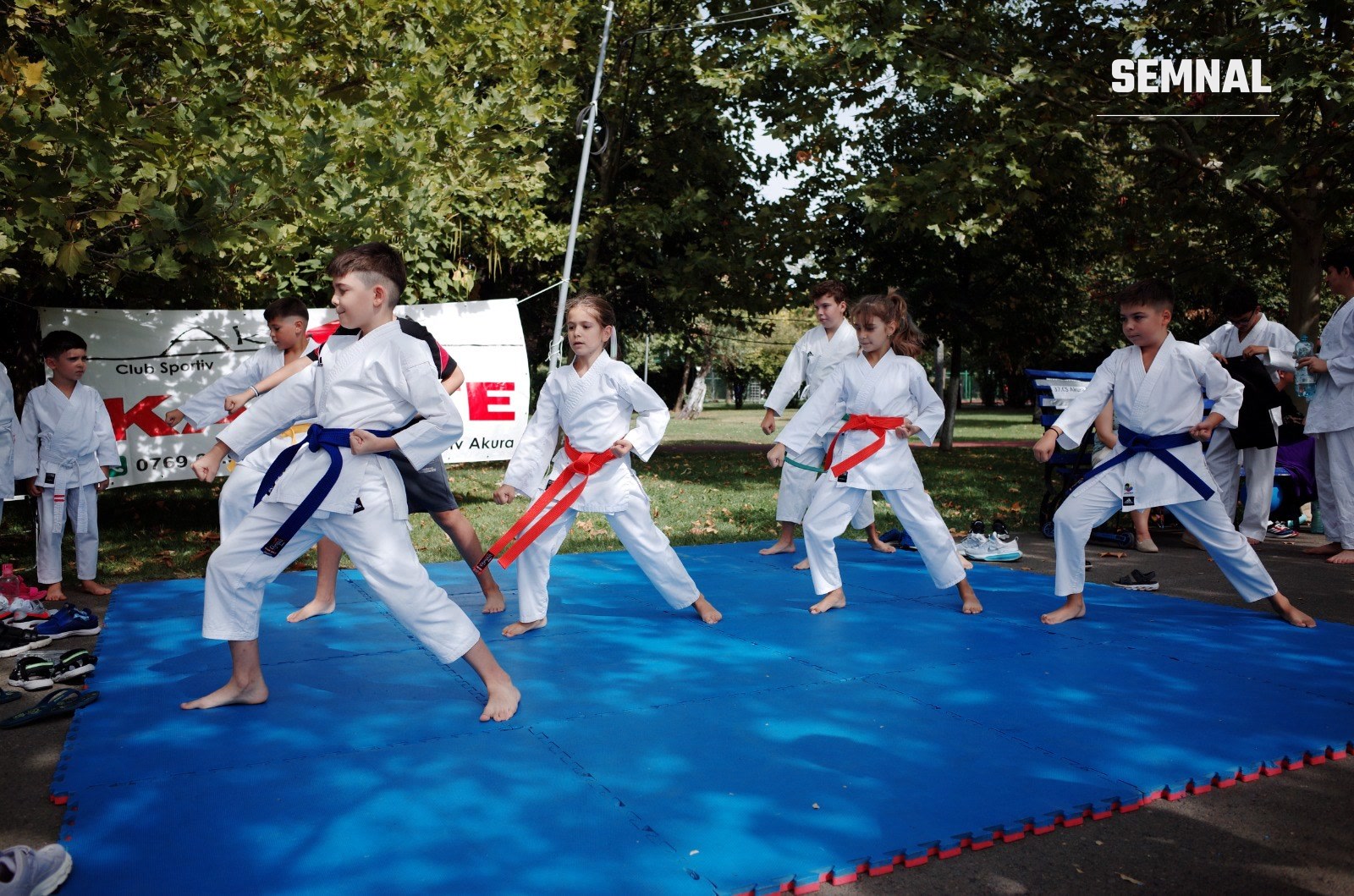 Copii la o demonstrație de karate a Clubului Sportiv Akura, pe tatami în parc