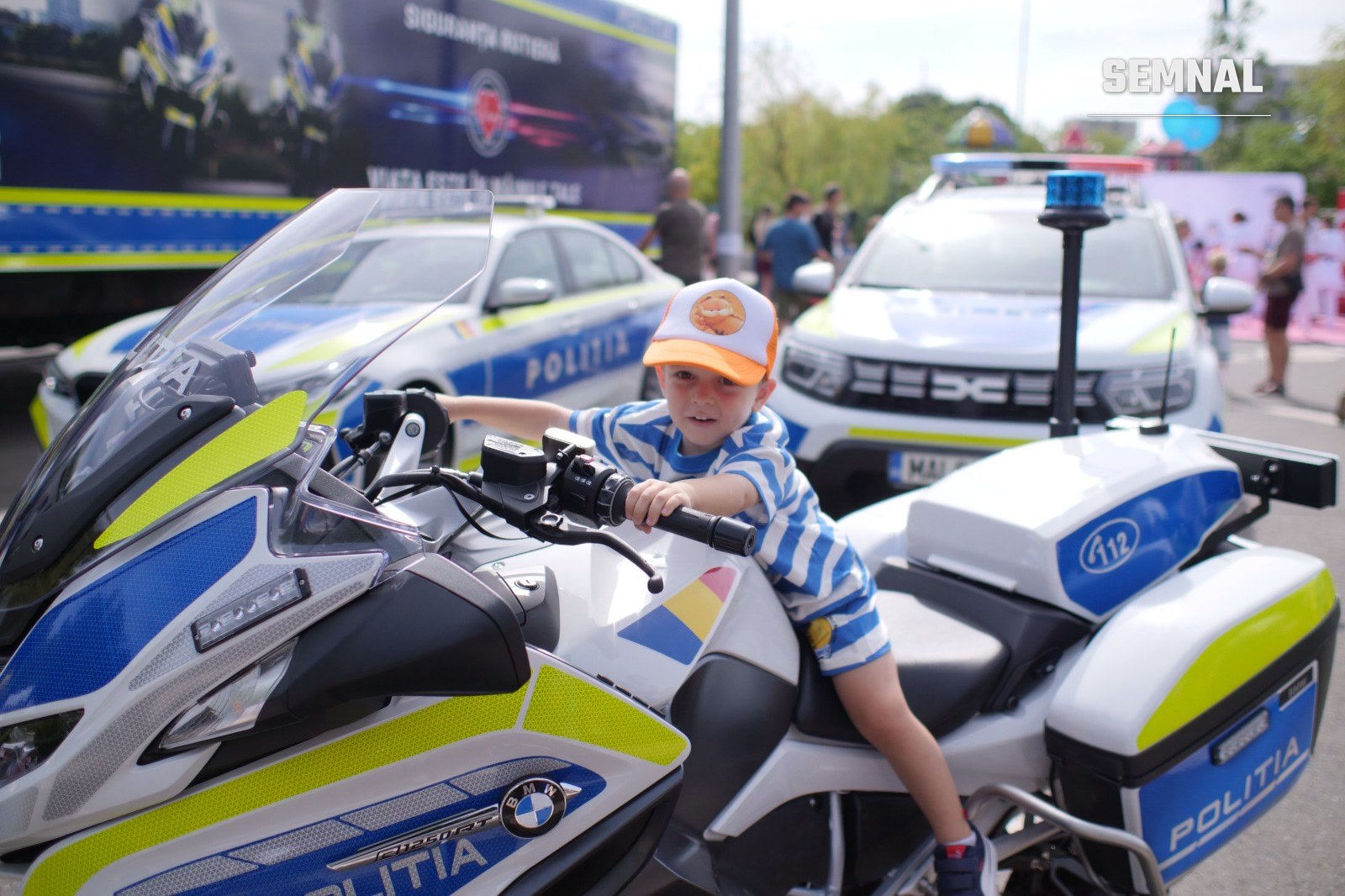 Un copil pe o motocicletă a Poliției Române, la standul de siguranță rutieră