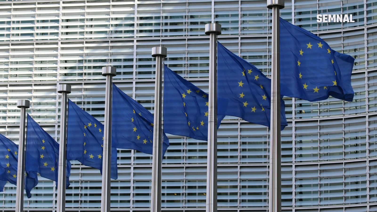 Steaguri ale statelor membre ale Uniunii Europene, aliniate în fața clădirii Berlaymont, sediul Comisiei Europene din Bruxelles