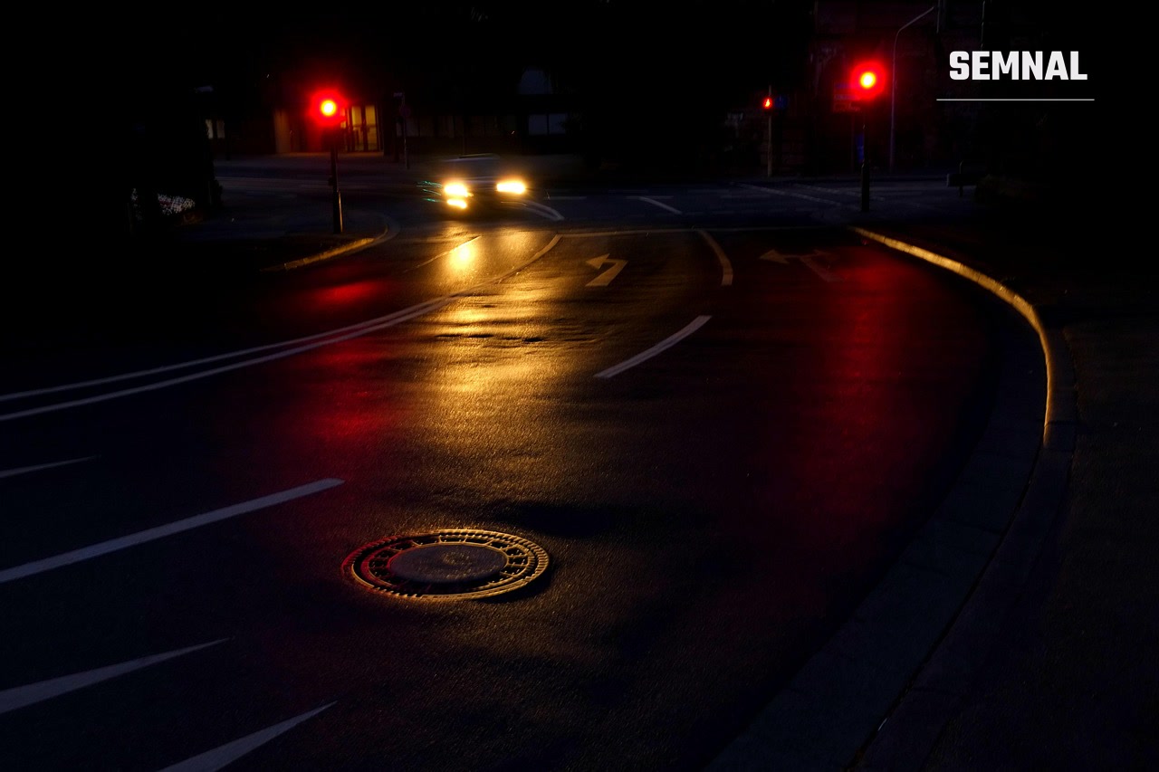 Drum urban noaptea, cu luminile unei mașini și reflexii roșii pe asfalt, imagine ilustrativă ( foto Pixabay)