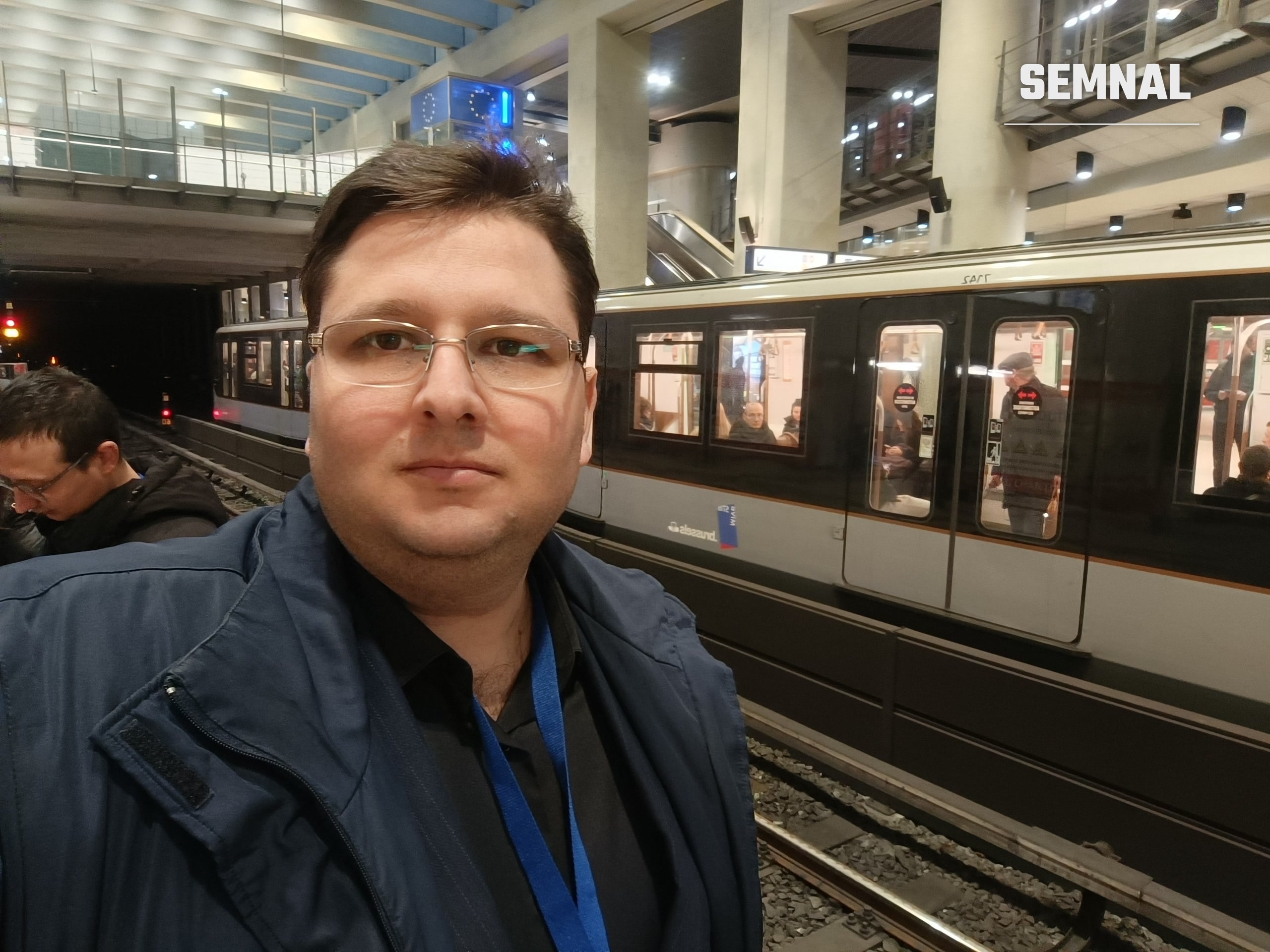 Lucian Dinu pe peronul stației Schuman, cu un tren de metrou oprit la linie