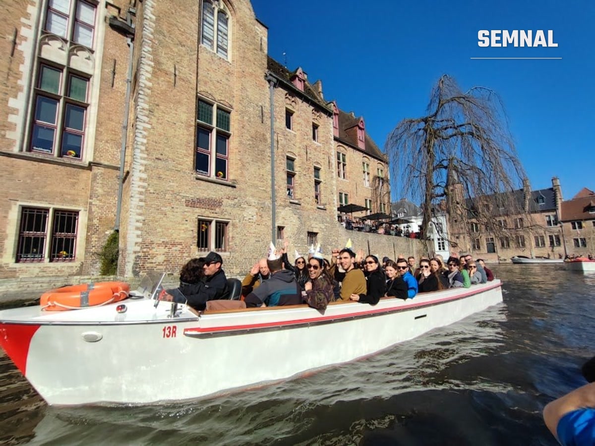 Barcă turistică pe unul dintre canalele Brugesului, cu pasageri la bord
