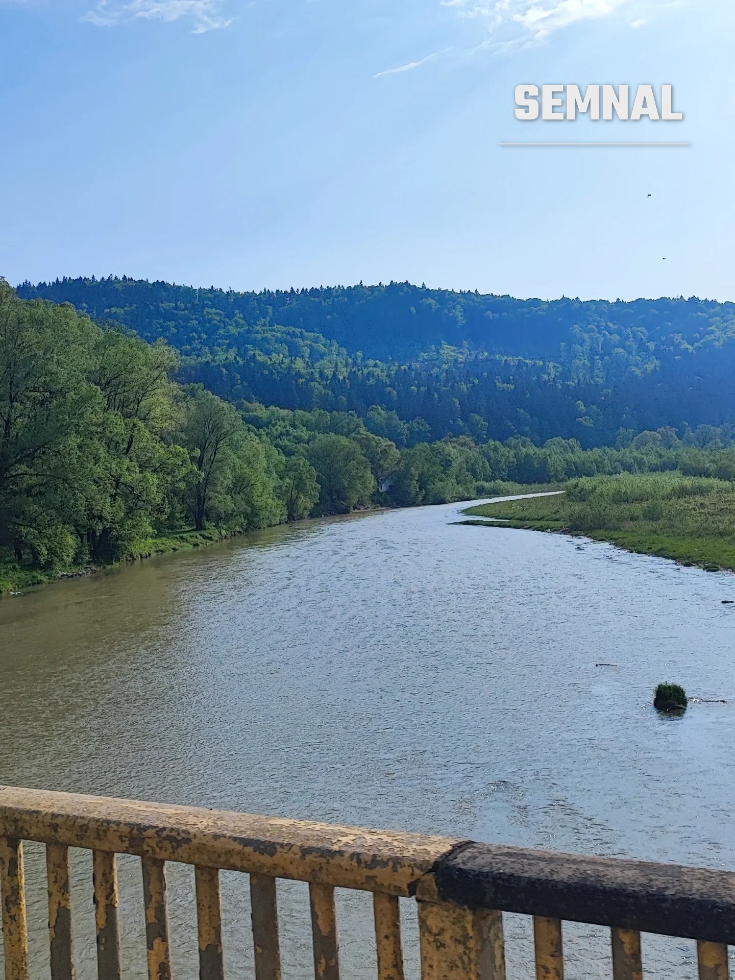 Valea unui râu din Bucovina, mărginită de păduri și dealuri