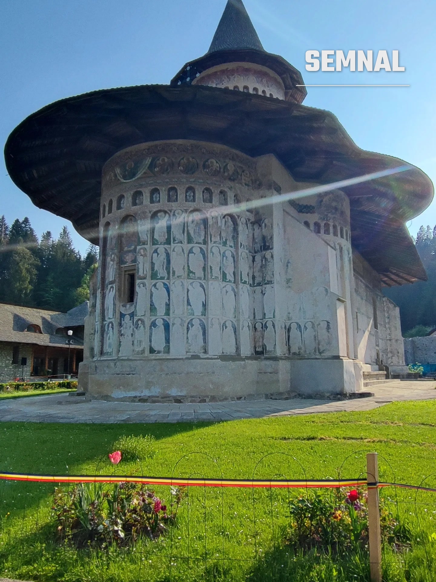 Detaliu al absidei pictate, cu o lalea înflorită și panglica tricoloră în prim-plan