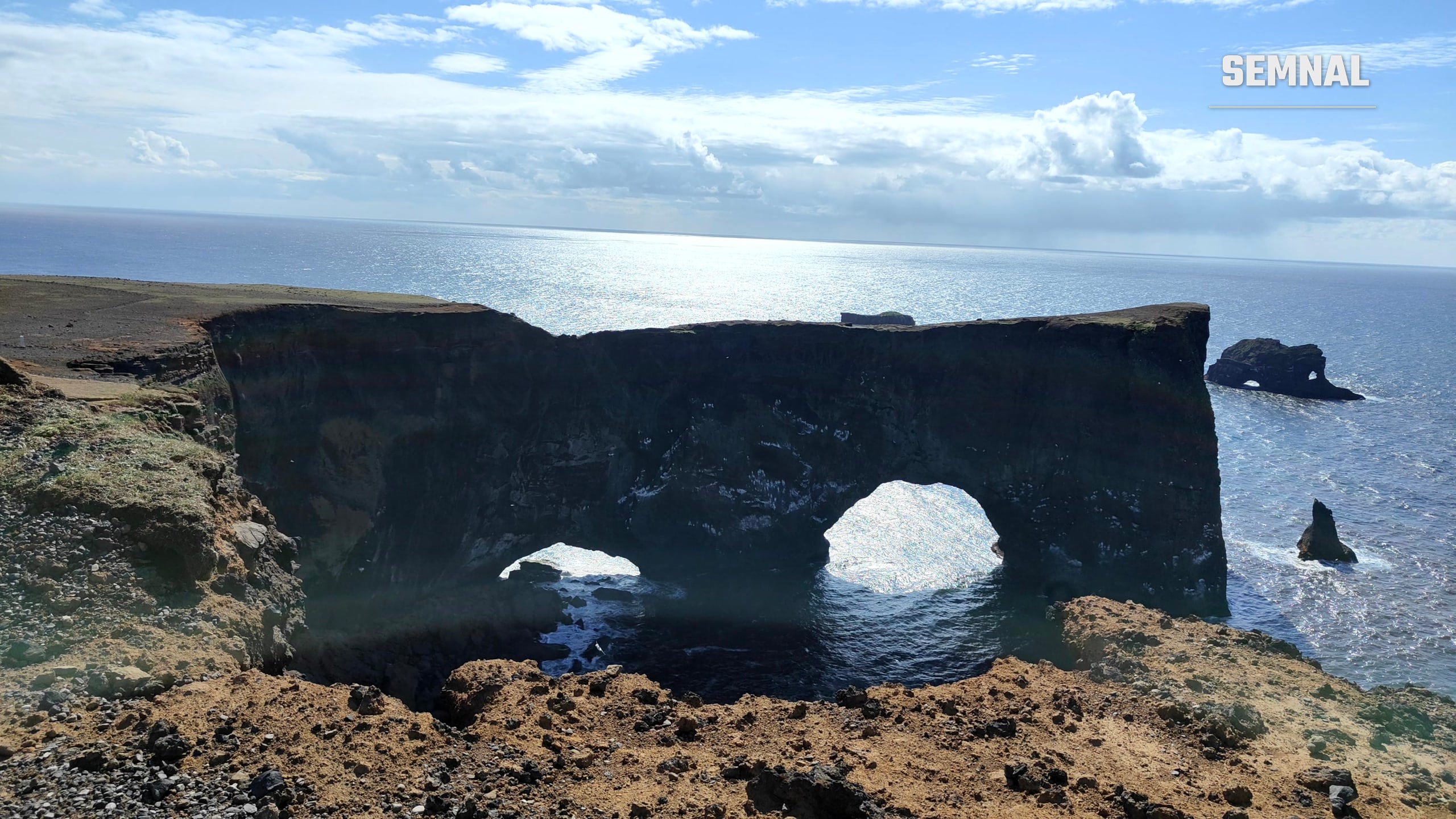 Stâncile și arcadele naturale de la Dyrhólaey, cel mai sudic punct al Islandei, cu oceanul în fundal