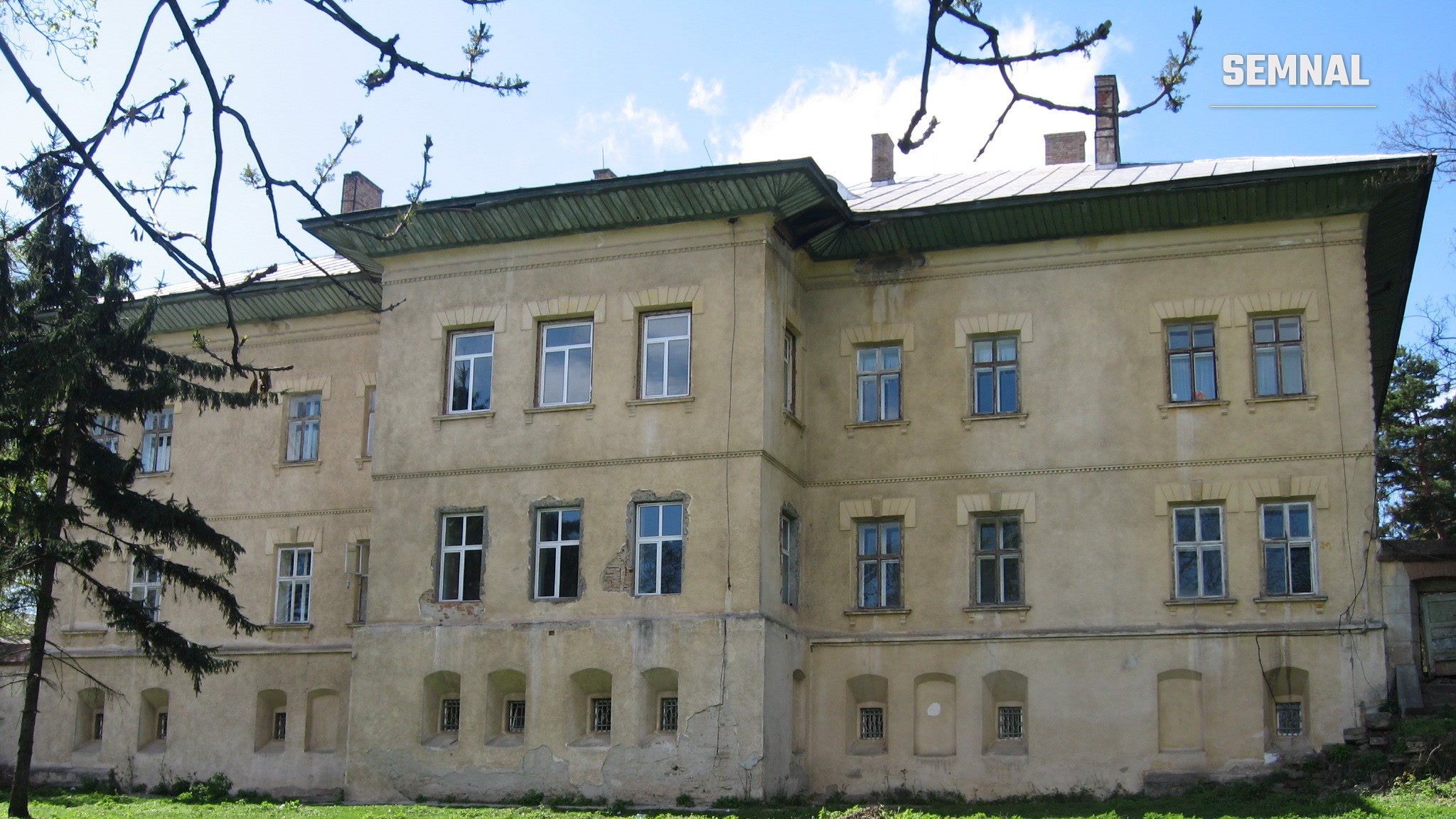 Fațada principală a Castelului Cantacuzino-Ghica din Deleni, județul Iași: clădire cu două etaje, pereți galbeni, ferestre cu ancadramente și streașină verde, văzută de pe peluză
