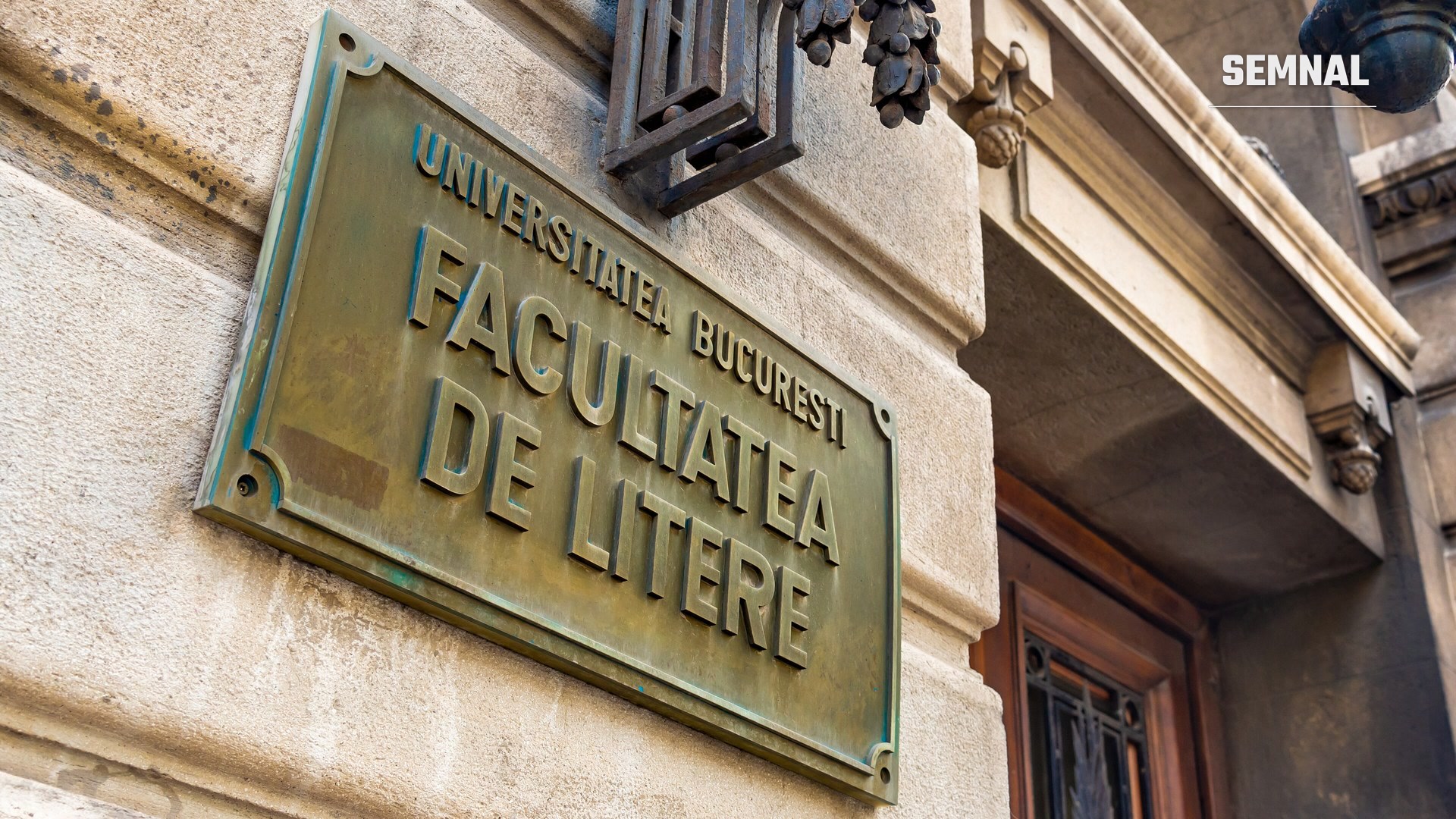 Placă de bronz cu inscripția „Universitatea București, Facultatea de Litere", fixată pe fațada de piatră a clădirii facultății