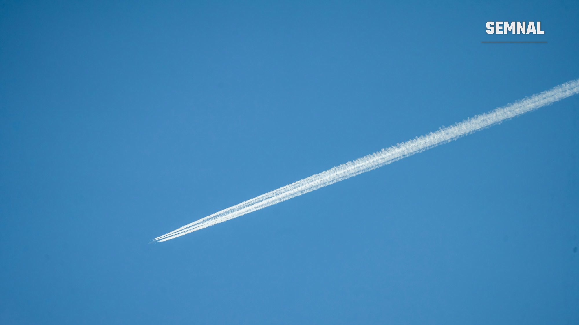 Dâră de condensare lăsată de un avion pe cer senin, imagine ilustrativă