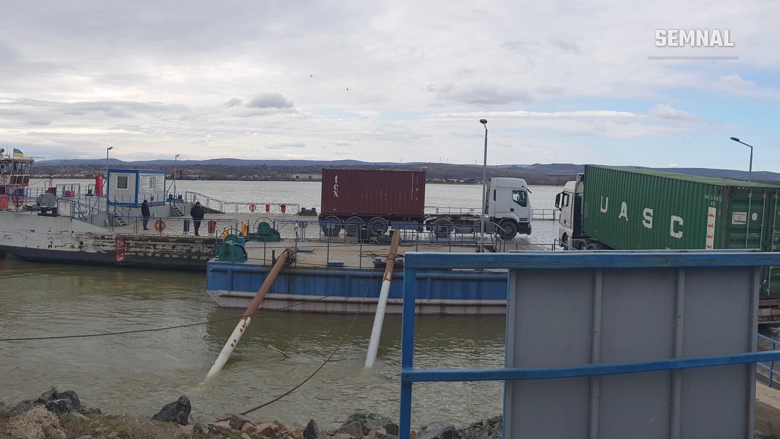 Feribotul dintre Orlivka (Ucraina) și Isaccea (România) pe Dunăre, cu camioane și containere la bord, în dreptul punctului de trecere a frontierei