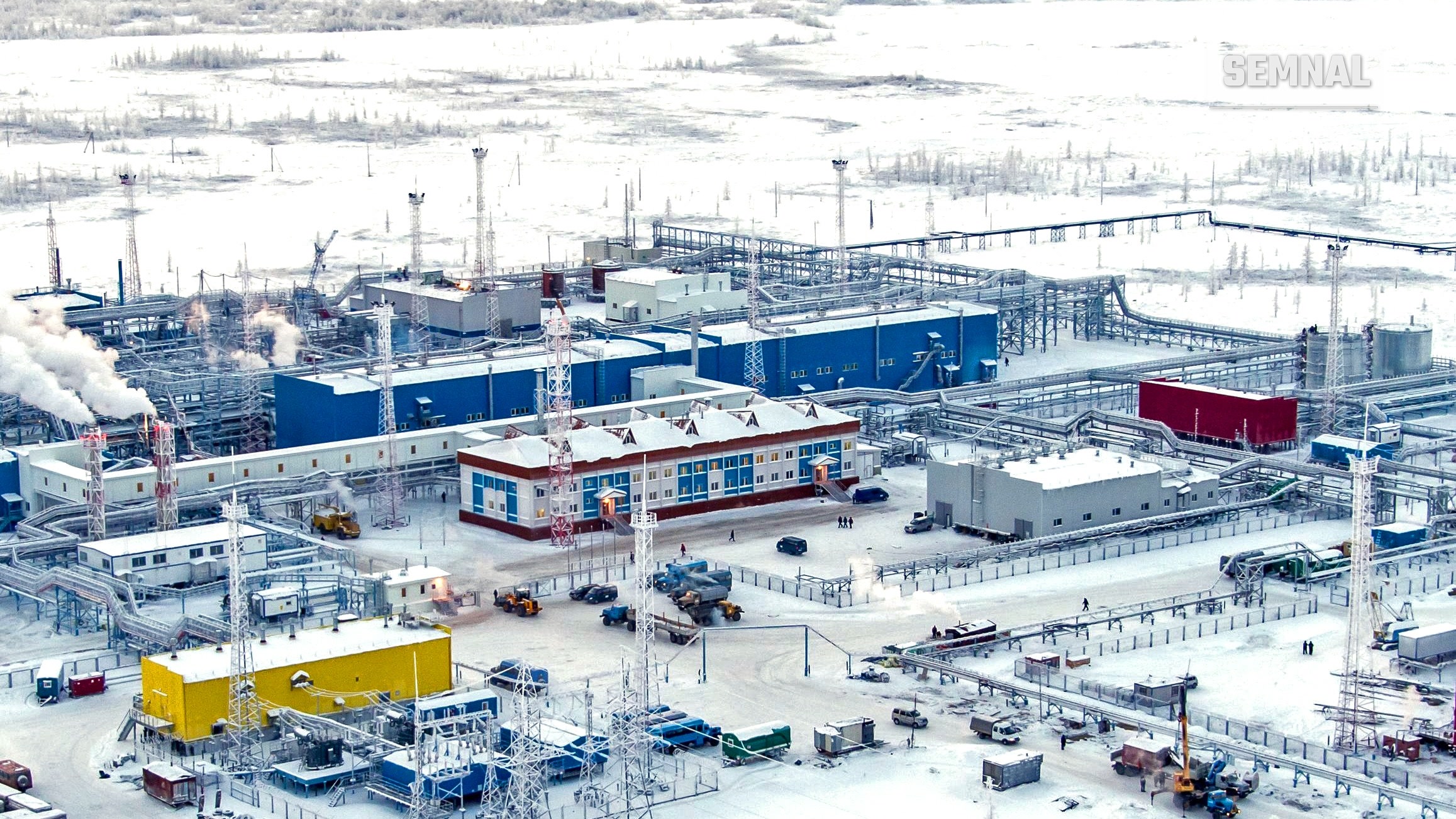 Vedere aeriană a instalațiilor de tratare a gazelor de la câmpul Zapolyarnoye, în nordul Siberiei, iarna, cu clădiri albastre și galbene pe zăpadă