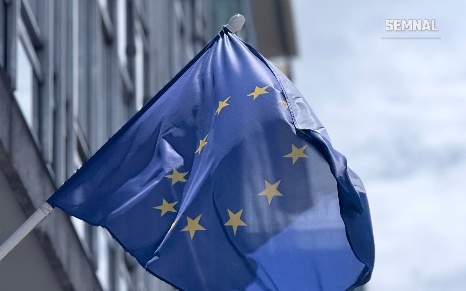 Drapelul Uniunii Europene fluturând lângă o clădire modernă