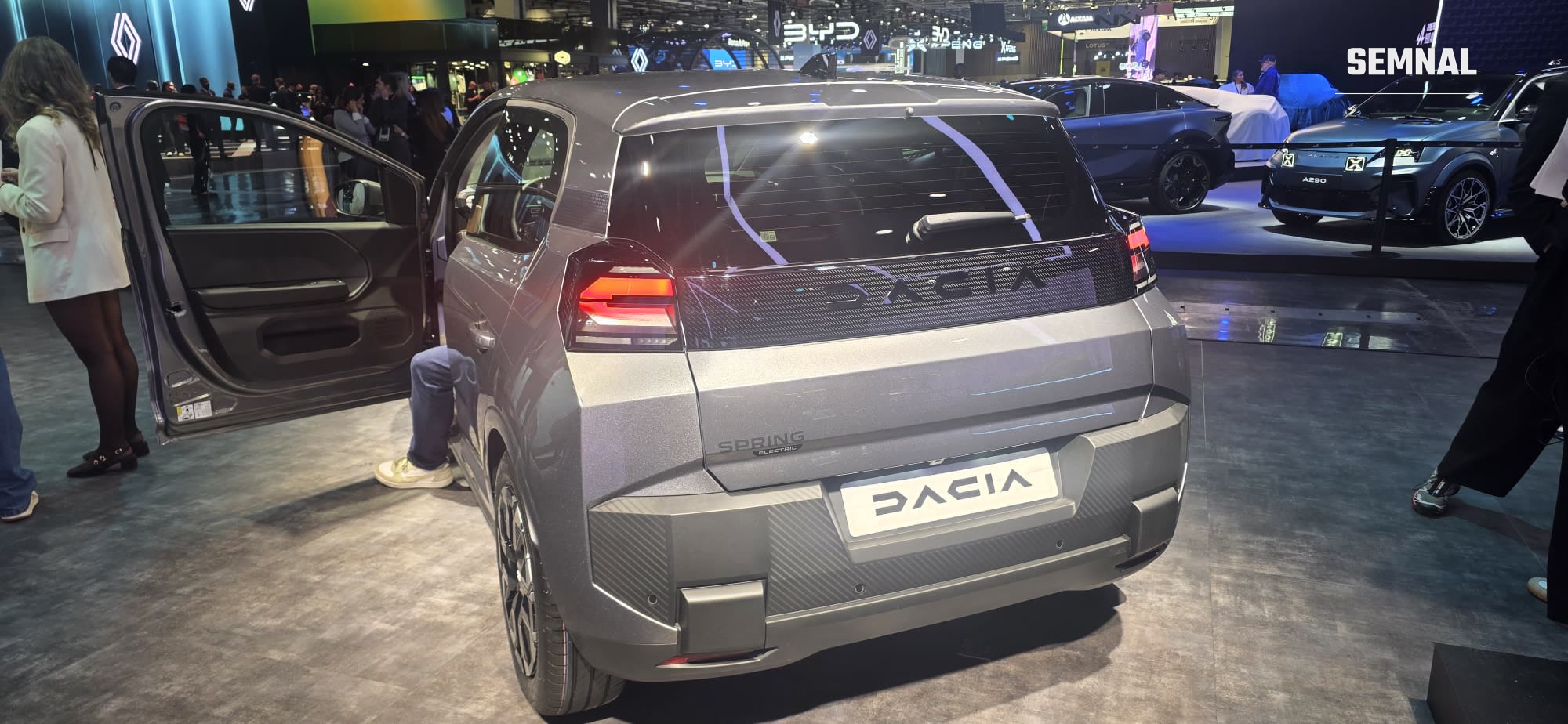 Partea din spate a noii Dacia Spring, cu Alpine A290 în fundal