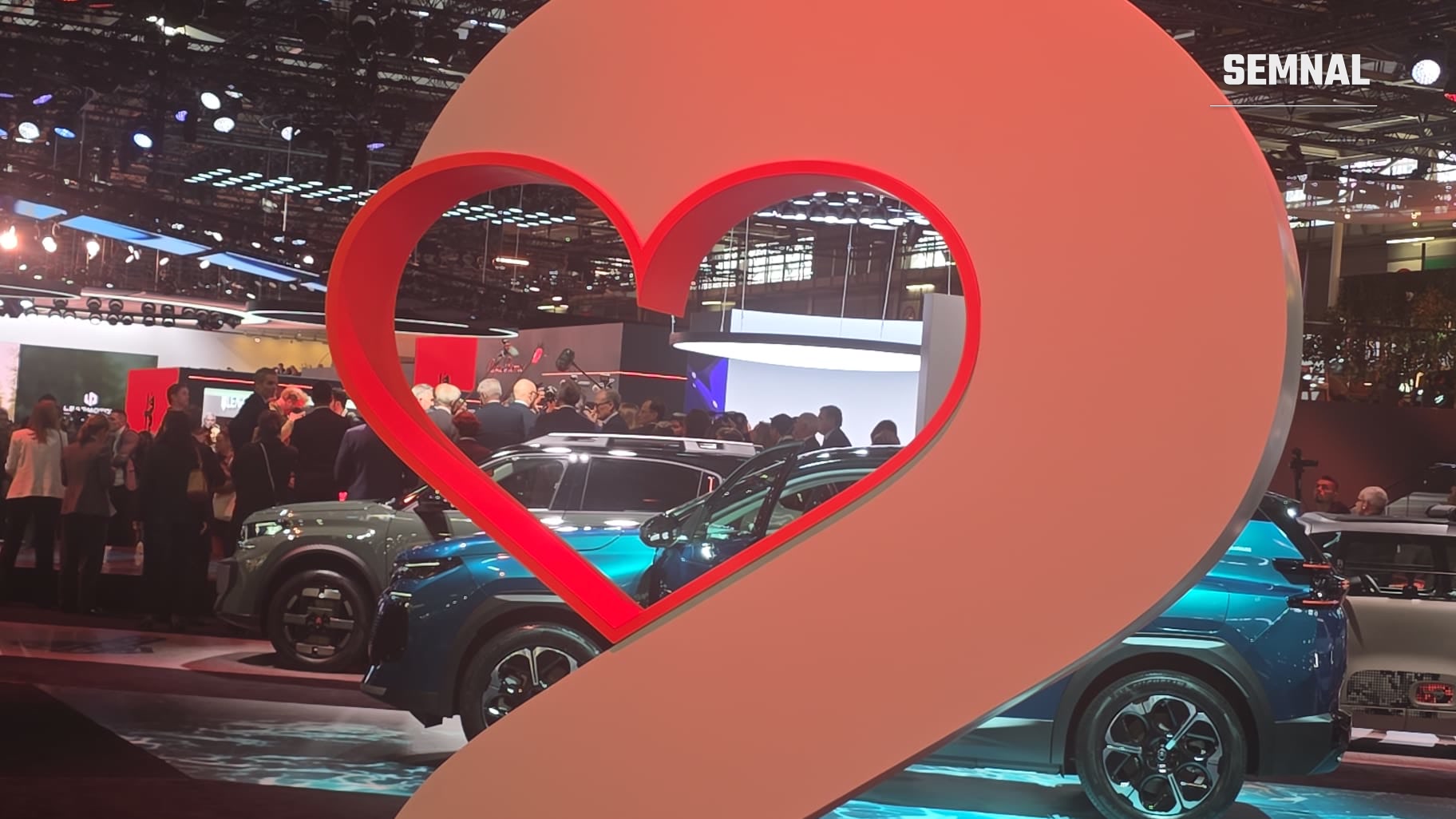 Vizitatori pe standul Citroën, văzuți prin decorul în formă de inimă