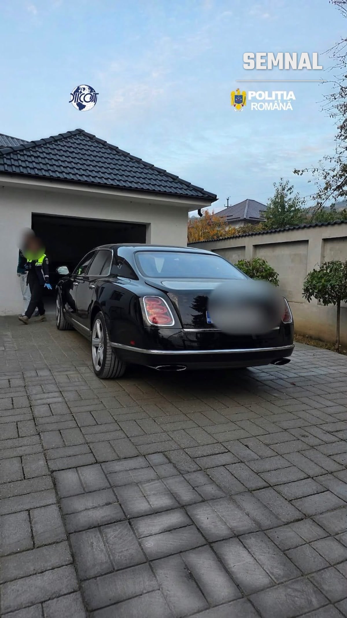 Autoturism de lux negru, în fața unui garaj. Foto: Poliția Română