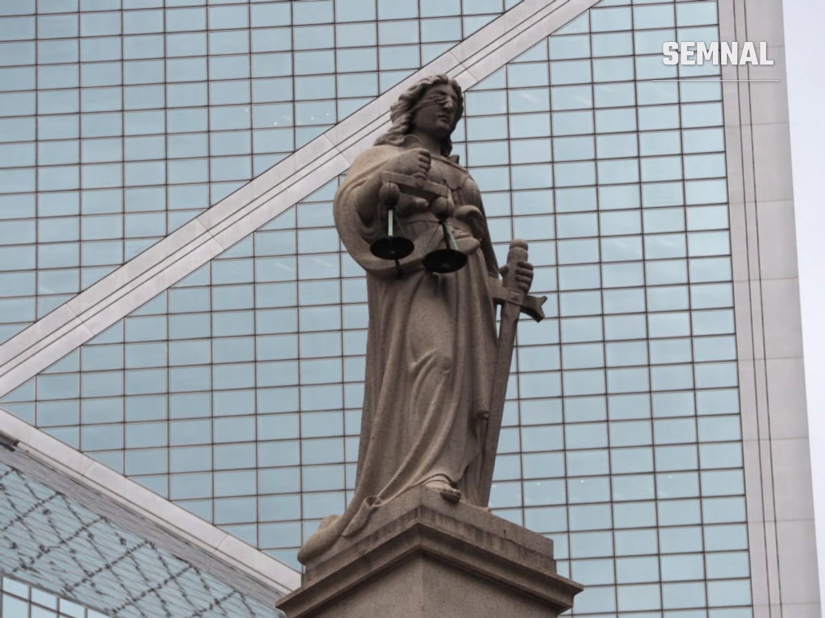 Statuie a Justiției cu balanța și sabia, în fața unei clădiri de sticlă, fotografie ilustrativă