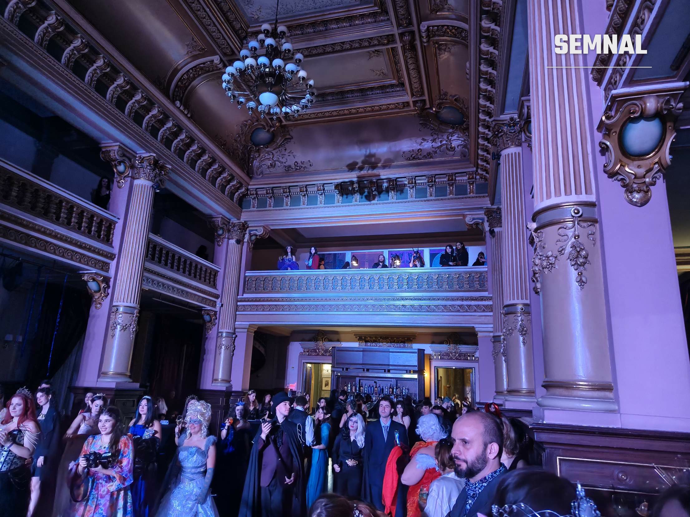 Invitați costumați în sala Palatului Bragadiru, sub candelabru, la The Night Court Ball