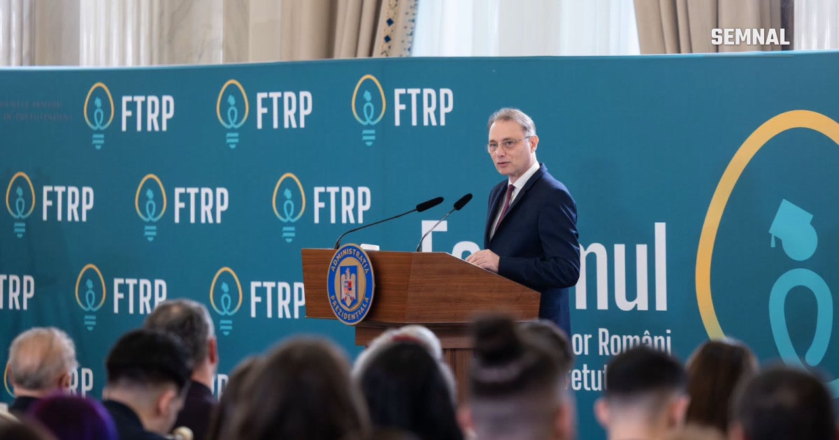 Premierul Luca Niculescu vorbind la un pupitru, în fața unui panou al Forumului Tinerilor Români de Pretutindeni, la Palatul Cotroceni