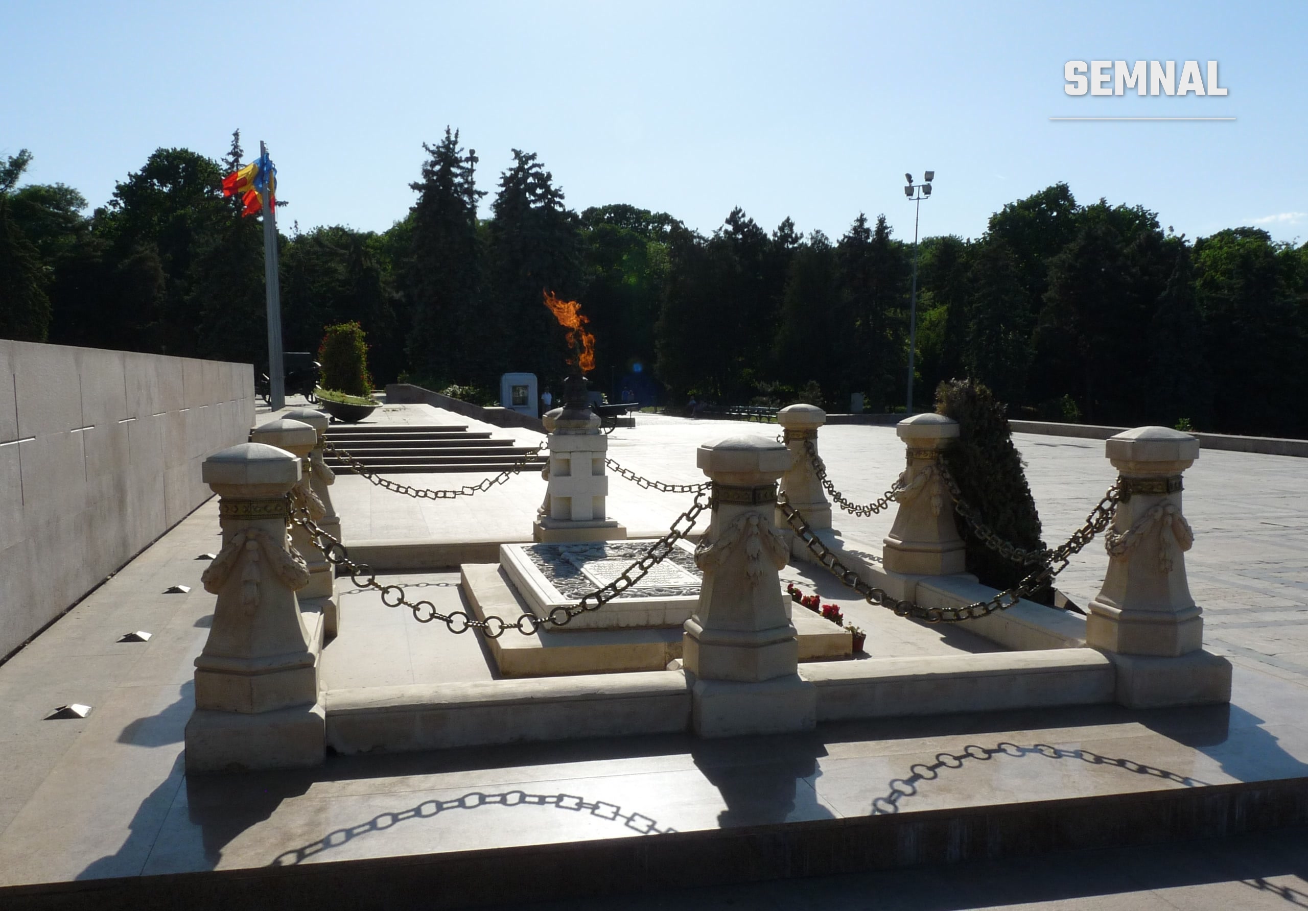 Mormântul Ostașului Necunoscut din Parcul Carol I, București, cu flacăra eternă și lanțurile din jurul monumentului. (Foto: Andrei Stroe / Wikimedia Commons, CC BY-SA 3.0)