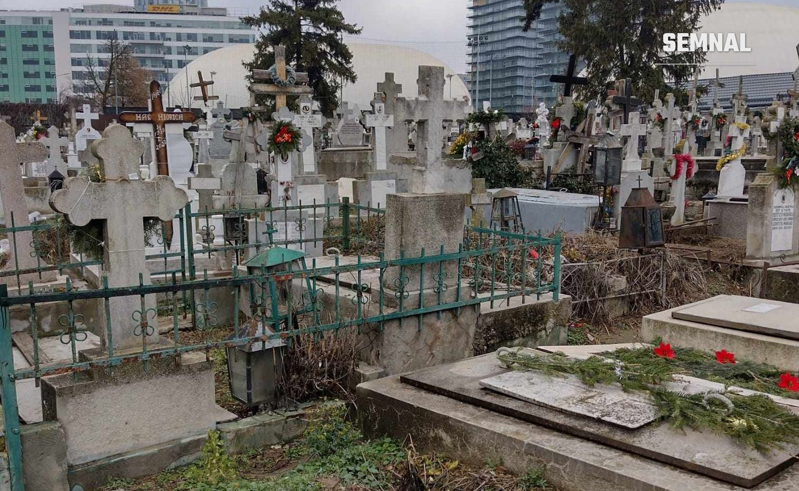 In imagine sunt cruci și cavouri dintr-un cimitir.