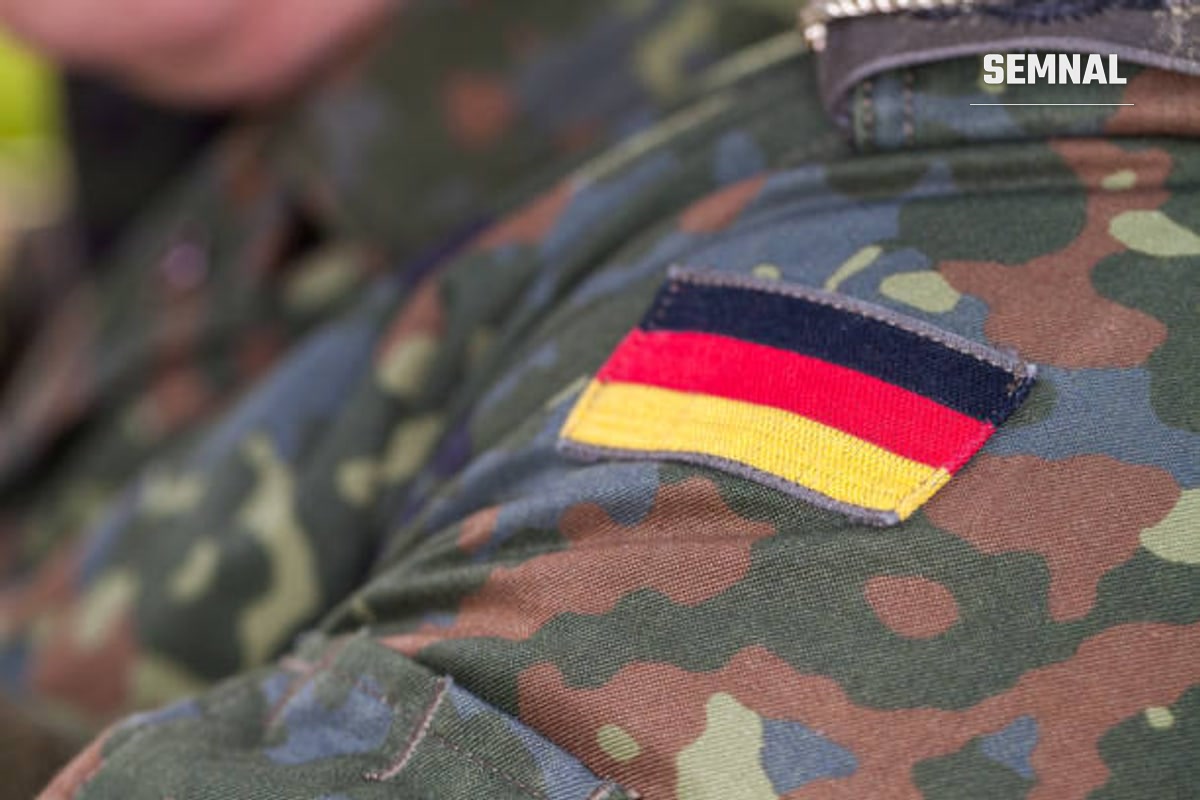 În imagine este un militar german, cu steagul Germaniei pe braț.