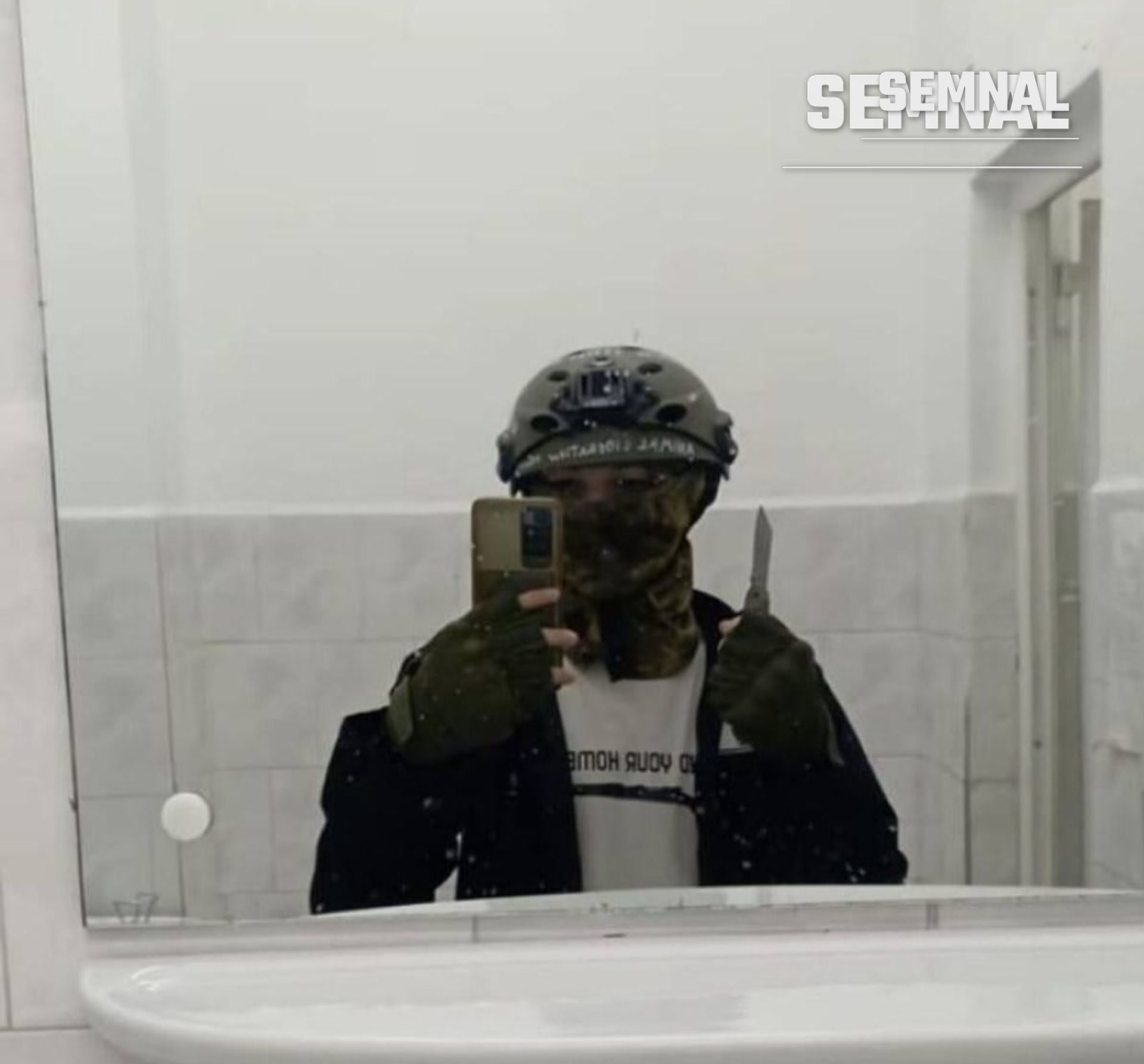 Imagine distribuită pe rețelele sociale, atribuită elevului suspectat de atac: tânăr cu fața acoperită, cască și cuțit, fotografiat în oglinda unei băi